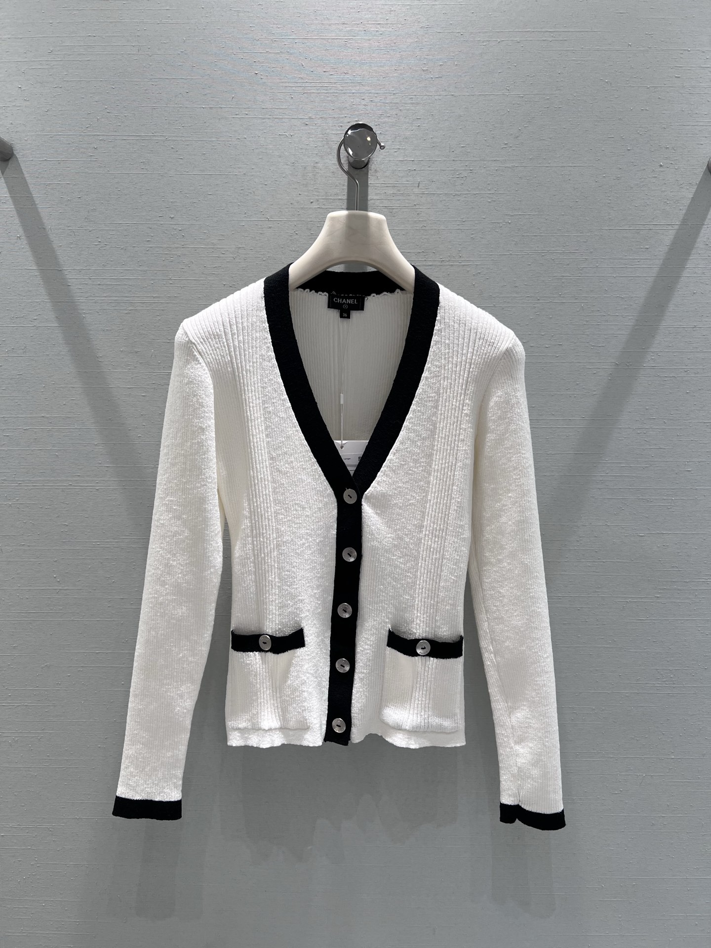 NO:736520,Support exchange Chan*L 2026SS early spring new product series // Contrast color V-neck knitted cardigan adopts a short waisted version. The V-neck design cleverly modifies the neck line. The ribbed knitted fabric has elasticity and fits the body shape without being tight. The contrasting edges on the placket and pockets echo the neckline design. It is matched with metal buttons of the same color, showing French elegance in every gesture. SML real shot details,,chanel,19860909支持换款Chan*L 2026SS早春新品系列//撞色V领针织开衫采用短款收腰版型,V领设计巧妙修饰颈部线条,罗纹针织面料自带弹力,贴合身形却不紧绷,门襟与口袋的撞色包边呼应领口设计,搭配同色系金属质感纽扣,举手投足间尽显法式优雅.SML实拍细节,,chanel,,Women's clothing