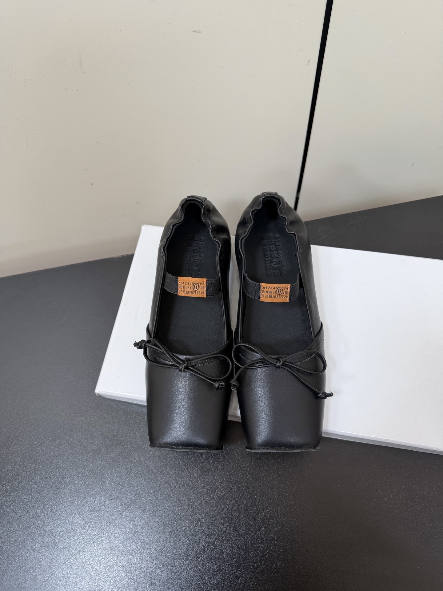 NO:706789,Maison Margiela square toe elastic band mm6 Margiela ballet flat Mary Jane shoes adopt the brand's iconic sculptural silhouette that fits the shape of the foot. The upper is soft and smooth, taking into account both fit and design. The square toe + ballet elements are combined with the classic square toe design to create a modern feel. It is matched with the bow decoration on the upper to reconstruct the elegant outline of the ballet shoes. At the same time, it is made into a mules back style, which is both casual and refined.  There is the iconic white single-thread stitching on the heel, and the elastic strap of the shoe body has the MM6 number logo, which is the key to brand recognition. The flat Mary Jane style simplifies the way of putting on and taking off, combining the softness of ballet shoes with the casualness of mules. The upper is retro burst cowhide, the lining is silk sheepskin, the outsole is genuine leather, and the height is 2cm.  margiela,mary jane,slippers,cowhide,sheepskin,leather soles19860909Maison Margiela方头弹力带mm6马吉拉芭蕾鞋平底玛丽珍鞋单鞋 采用品牌标志性的贴合脚型的雕塑感轮廓,鞋面柔软且线条流畅,兼顾贴合度与设计感.方头+芭蕾元素融合经典方头设计打造现代感,搭配鞋面蝴蝶结装饰,重构芭蕾鞋的优雅轮廓,同时做穆勒拖的后空款式,兼具休闲与精致. 鞋后跟处有标志性的白色单线缝线,鞋身弹性带带有MM6数字标识,是品牌辨识度的关键.平底玛丽珍款式,简化穿脱方式,将芭蕾鞋的柔美与穆勒鞋的随性结合. 鞋面复古爆裂牛皮 内里丝绸羊皮里 大底真皮大底 增高2cm size :35-41码（40码定制不退换）,拖鞋芭蕾舞鞋,masion margiela,masion margiela,mary jane,slippers,cowhide,sheepskin,Leather soles,Women's Shoes