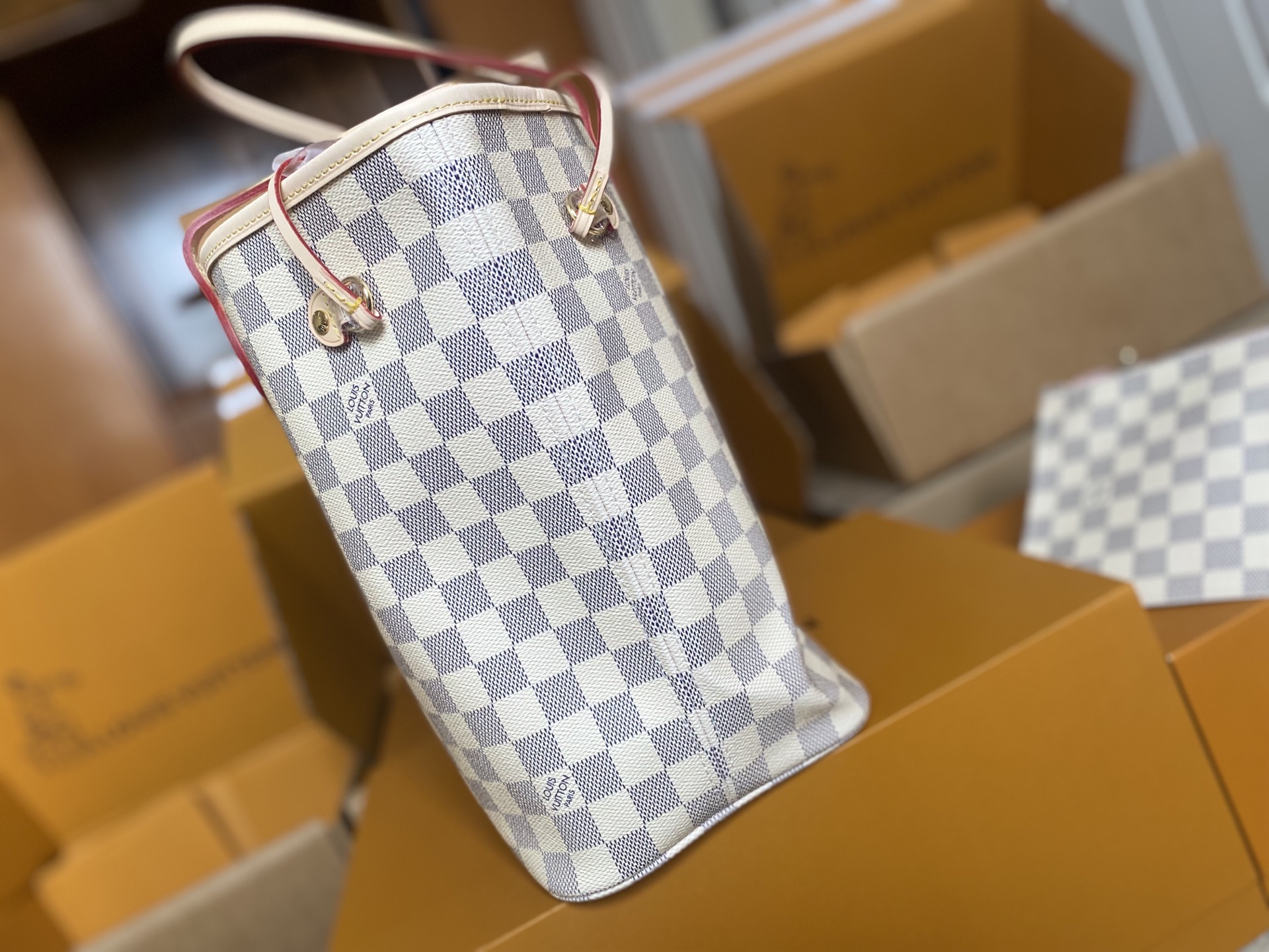 p450。 顶级原单 N41605 白格粉色新版新版本✨N41361 白格杏色 本款 Neverfull 中号手袋结合了经典设计与标志性细节。由清新 Damier Azur 帆布制成，采用多彩织物内衬，并搭配牛皮革饰边，宽敞却不臃肿。束紧两侧成就潮流风范，舒展即现休闲气质。配有纤薄手柄，可肩背或肘挎。可拆卸手袋可用作手拿包或口袋。
详细特征

31 x 28 x 14 厘米 
(长度 x 高 x 宽)
