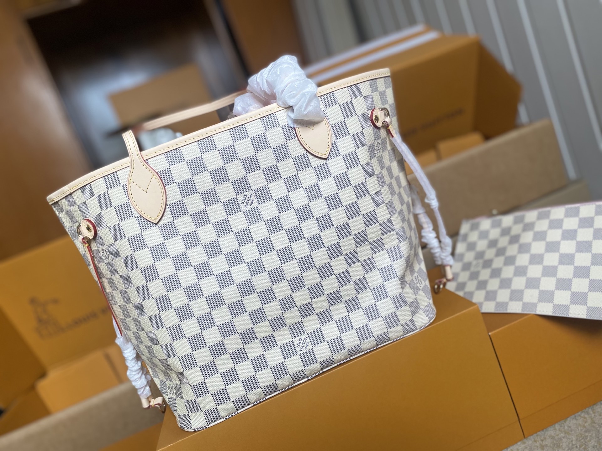 p450。 顶级原单 N41605 白格粉色新版新版本✨N41361 白格杏色 本款 Neverfull 中号手袋结合了经典设计与标志性细节。由清新 Damier Azur 帆布制成，采用多彩织物内衬，并搭配牛皮革饰边，宽敞却不臃肿。束紧两侧成就潮流风范，舒展即现休闲气质。配有纤薄手柄，可肩背或肘挎。可拆卸手袋可用作手拿包或口袋。
详细特征

31 x 28 x 14 厘米 
(长度 x 高 x 宽)
