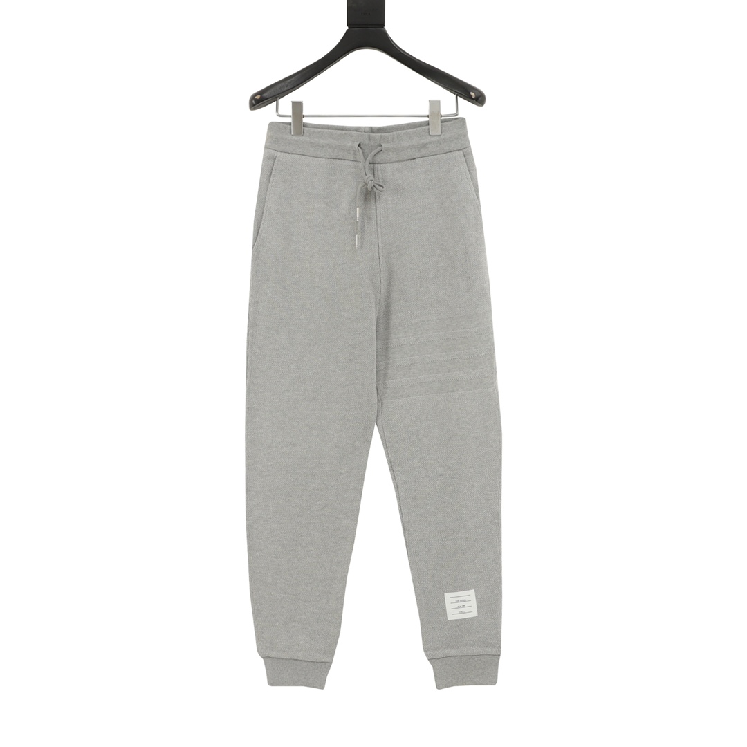 Thom Browne/汤姆布朗 暗纹四杠束腿长裤 420克定织定染成衣定制面料打造而成，采用罗纹圆机十字罗纹织法，32支3股纱并入针孔，超重工的紧密针织工艺，使面料表面呈现出细腻的肌理感，手感柔和厚实挺滑，有一定的自重感，同时也拥有着良…