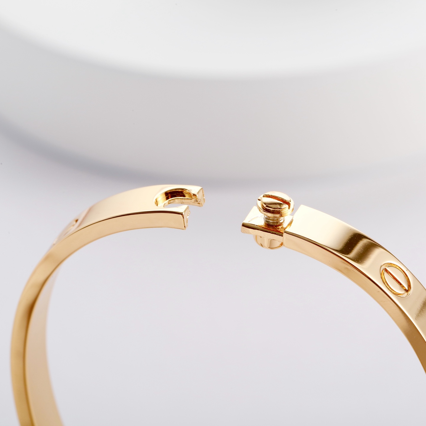 Cartier 卡地亚的Love系列手镯以其独特的设计而备受喜爱 这款宽版无钻玫瑰金手镯更是爱情的完美见证