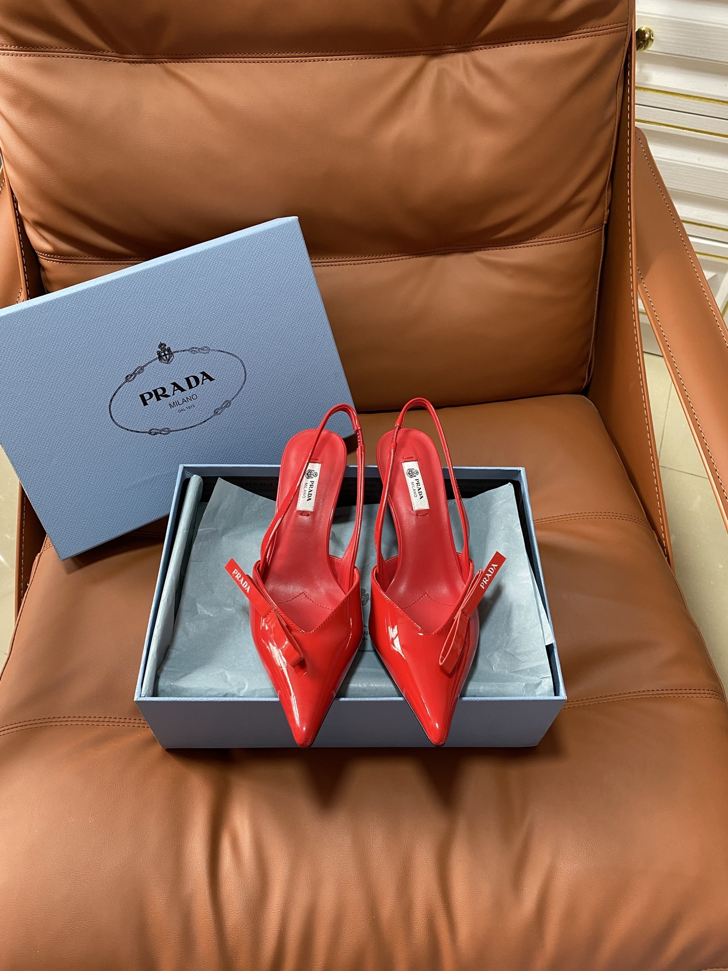 NO:875345,PRAD*25ss retro triangular pointed-toe kitten heel. The Prada triangle logo is embedded in the toe, which is a highly recognizable symbolic element of the brand and strengthens the visual memory point. The pointed-toe outline modifies the foot shape while adding an elegant and capable temperament, which is in line with Prada's consistent exquisite style. The thin strap design at the heel is both decorative and practical, which not only fixes the ankle, improves wearing stability, but also weakens the heavy feeling of high heels.  The heel height is moderate, creating an aura while ensuring walking comfort, suitable for the workplace or daily commuting scenes. The shoes are lined with genuine leather, which is skin-friendly and breathable, reducing the stuffiness and friction discomfort caused by long-term wear. Patent leather upper, sheepskin lining, leather outsole, size 35-41 (customized sizes 40 and 41 are non-refundable), high-heeled sandals, prada, sandals, high heels, sheepskin, Leather soles19860909PRAD*25ss 复古三角标尖头小猫跟 鞋头处嵌入Prada三角徽标,这是品牌辨识度极高的符号元素,强化视觉记忆点.采用尖头轮廓,修饰脚型的同时增添优雅干练气质,契合Prada一贯的精致风格.后跟处的细带设计兼顾装饰性与实用性,既固定脚踝、提升穿着稳定性,又弱化高跟鞋的厚重感. 鞋跟高度适中,在营造气场的同时保障行走舒适度,适合职场或日常通勤场景.鞋内采用真皮衬里,亲肤透气,减少长时间穿着的闷热感与摩擦不适感. 鞋面漆皮 内里羊皮 大底真皮大底 size35-41码（40、41码定制不退换）,高跟鞋凉鞋,prada,sandals,high heels,sheepskin,Leather soles,Women's Shoes