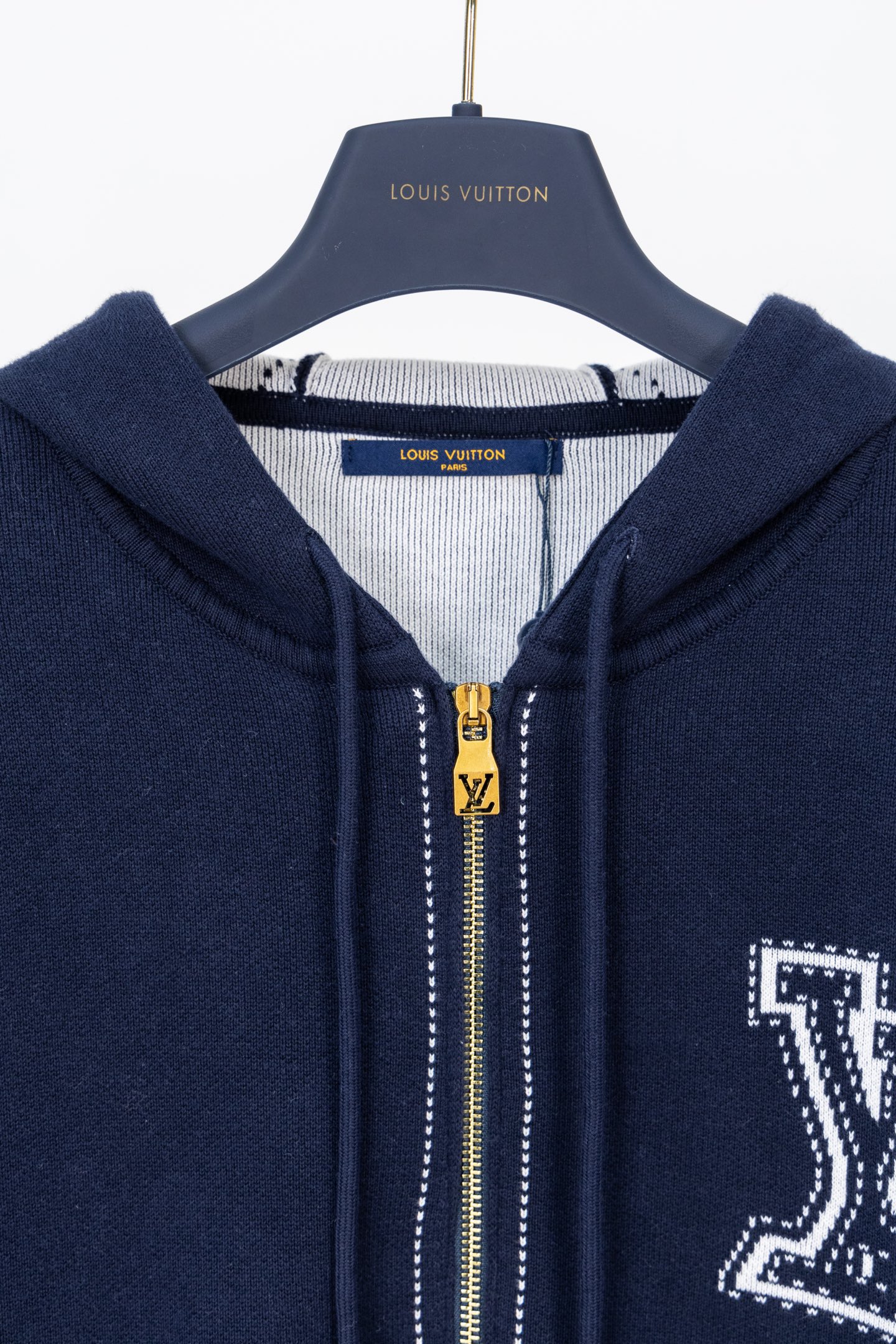 💰245【顶级版本.官网品质】
LOUIS VUITTON*路易威登
LV  针织嵌花拉链开衫外套

面料：采用纯棉毛纱，定织碳化黑毛纱使衣服色光更加呈现出亮光黑效果。
工艺：成衣洗水固定版型增加手感。
工艺：该款采用14针进口机器织出，提花工艺打板6次才完美复刻而成。
辅料：拉链采用电镀黄铜色，拉牙采用欧款拉牙，

这款黑色棉质拉链运动衫采用精致的嵌花工艺，虚线营造出缝合和刺绣的错觉。正面饰有对比鲜明的LV首字母，而超大Mo nogram 花朵则为肘部增添了图形感。这款服装具有休闲时尚的魅力，可以为服装增添一层舒适的温暖。
面料:100%棉颜色:黑色和白色胸前镶嵌LV缩写
肘部镶嵌大型Monogram 花朵。
连帽配有抽绳，金属末端刻有LV首字母拉链开合和拉头刻有LV缩写肋骨上带有压花效果的条纹图案大侧袋常规版型。

款号：9606#
颜色：黑色 蓝色
尺码：S M L XL