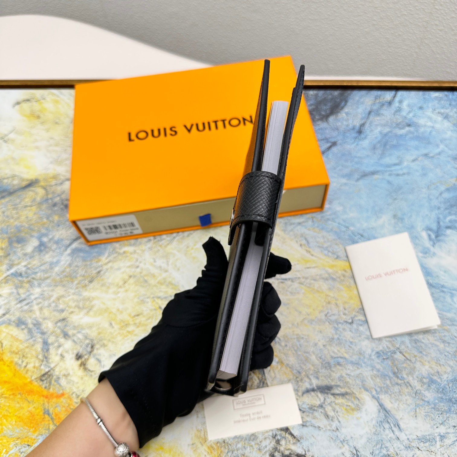 Notebook compared to a hand to show size.