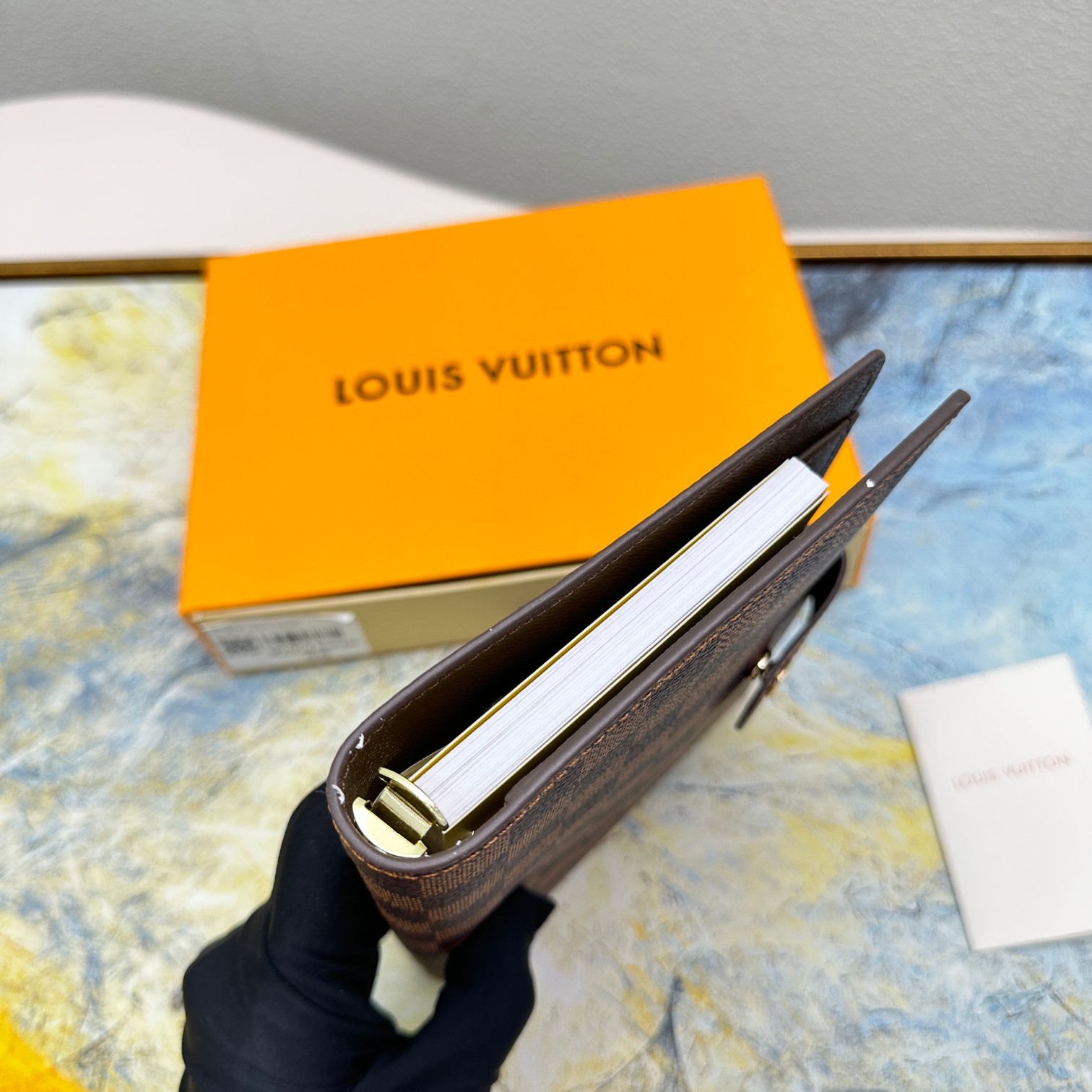 Notebook compared to a hand to show size.