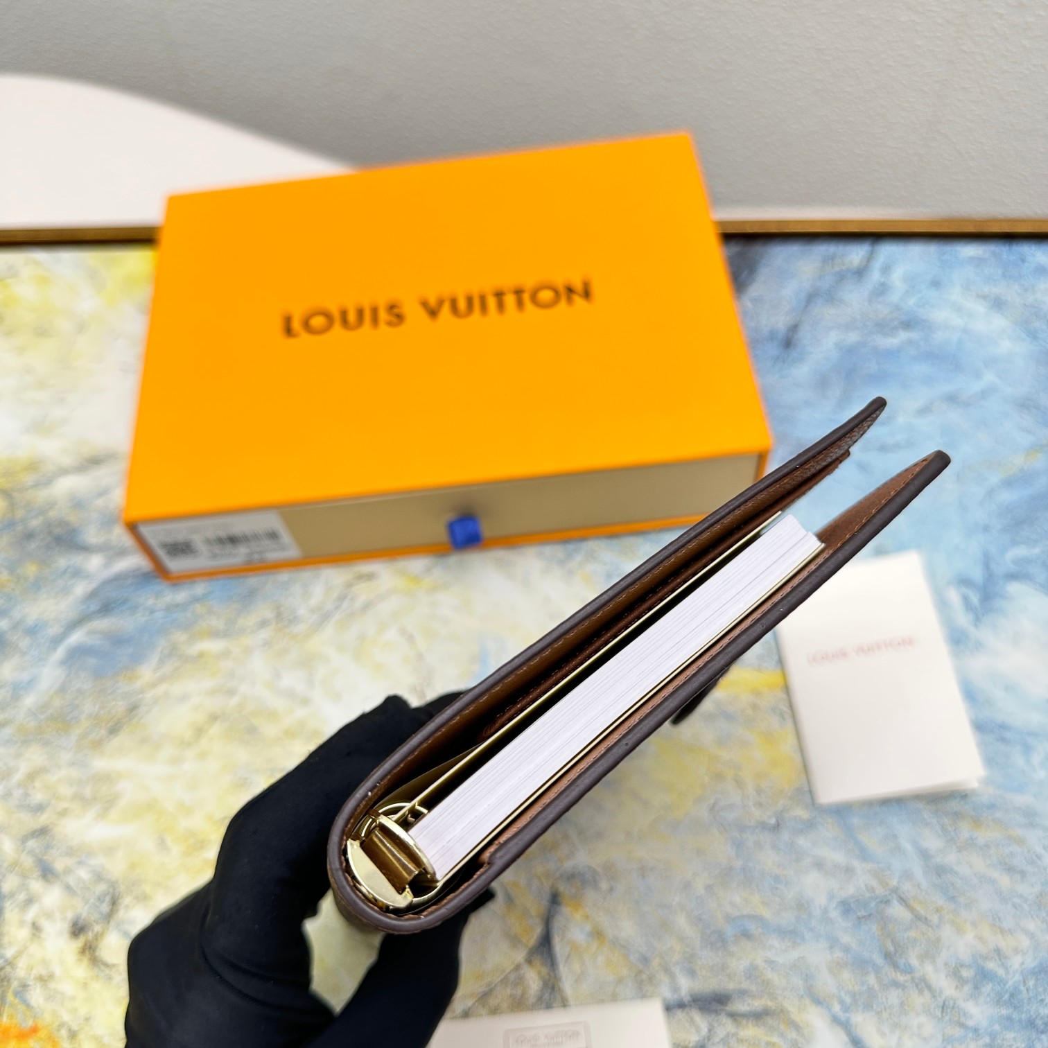 Notebook compared to a hand to show size.