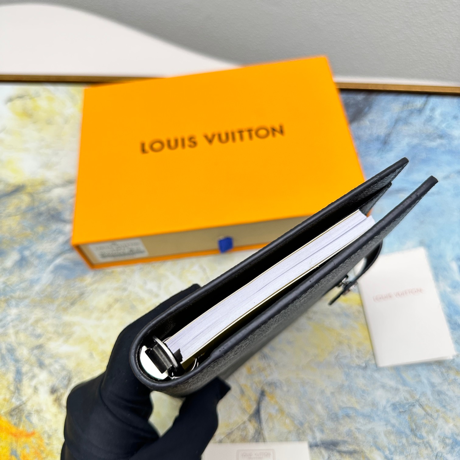Notebook compared to a hand to show size.
