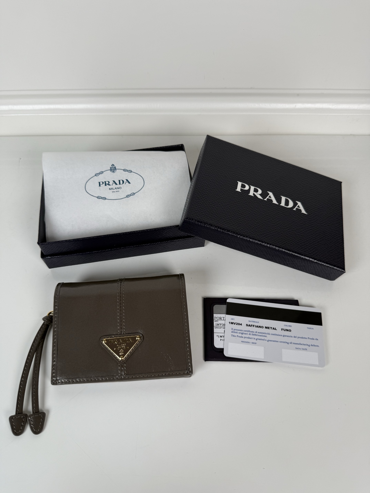 NO:672476,, P family women's two-fold short clip, model 1M0204, gray waxed cowhide, length 11.2 height 9.5cm, simple and practical to enhance personal taste, 175 steel stamp, Prada, prada, cowhide19860909,P家女士两折短夹,型号1M0204,灰色油腊牛皮,长度11.2高度9.5cm,简单实用提升个人品味的一款,175钢印,普拉达,prada,cowhide,欧美剧