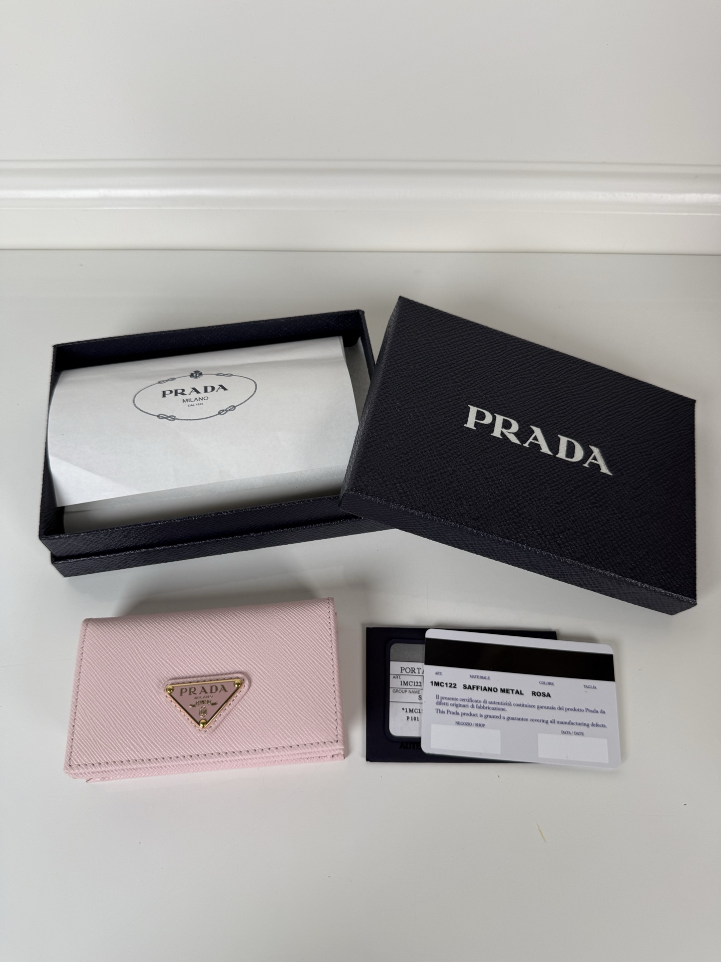 NO:919963,,P's classic card holder, model 1MC122, made of cross-grain cowhide, size 6.5×2.5×11cm, adopts snap button opening and closing design, with two card or receipt slots inside. This exquisite card holder is small and convenient, with sufficient capacity. It can be placed in the bag for easy storage. It can also be used for daily use when going out to make single items. Hot best-selling model, real shot, what you see is what you get, Prada, prada, cowhide19860909,P家经典卡片夹,型号1MC122,十字纹牛皮制作,尺寸6.5×2.5×11cm,采用按扣开合设计,内有两个卡片或票据插口,这款精致的卡夹小巧方便,容量充足,放置于包包内方便收纳,也可日常出门做单品用,火爆热卖款,实物拍摄,所见即所得,普拉达,prada,cowhide,欧美剧