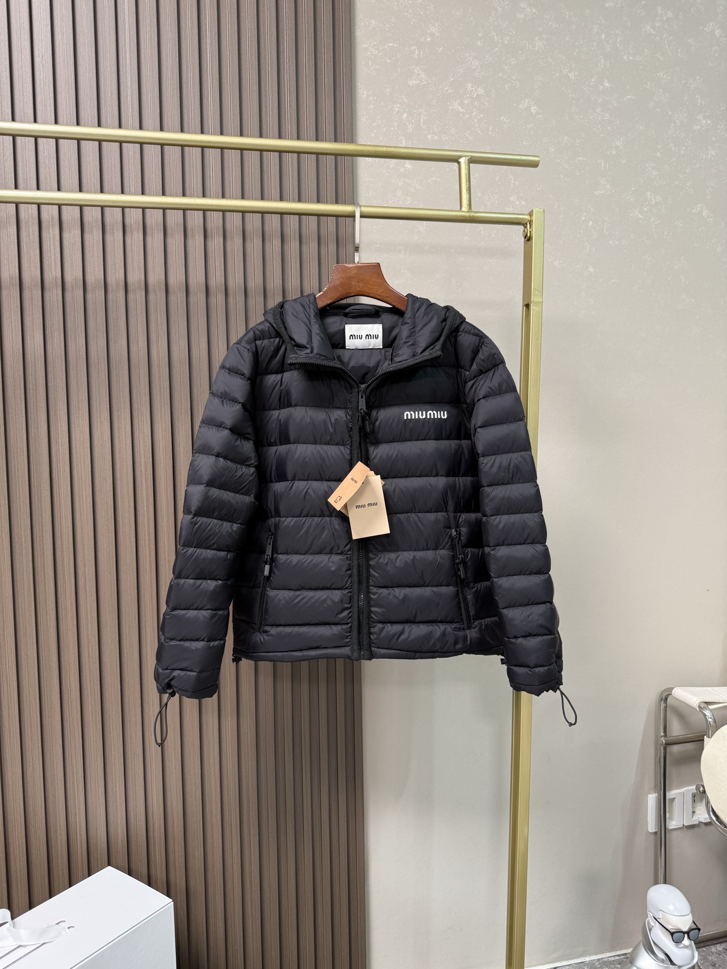 NO:576848,Miumiu hooded down jacket with dust bag｜Lightweight protection in winter, quality explained in details] This miumiu hooded down jacket is designed with a classic regular fit, taking into account comfort and neat style, and is suitable for a variety of body shapes. The sleeves are fitted and cut to allow free movement without restraint. The hooded collar design is not only windproof and warm, but also gives the overall look a casual and sporty atmosphere. The drawstring cuffs fit tightly around the wrist, effectively locking in temperature and wind, and preventing the intrusion of cold wind;  The hem is equipped with an elastic drawstring, which can be freely adjusted to further enhance the warmth performance and personalized appearance. The zipper pocket is designed to be safe and practical, convenient for storing personal belongings; the custom hardware zipper is smooth and durable, and the details highlight the texture. The exquisite 10,000-needle embroidery logo is a low-key embellishment of the brand identity. Fabric selection  Customized high-quality nylon material, although light, its wear resistance is one of the best among all textile fibers, far exceeding natural fibers and even many other synthetic fibers. Nylon fabric also has good elasticity, is not easy to wrinkle, and has good shape retention. High-quality filler uses 90 national standard high-quality down, with a filling capacity of 180 grams. It has high fill power, strong warmth retention, lightness and no burden, and can easily cope with cold weather.  Whether for urban commuting or outdoor leisure, this down jacket has become an indispensable luxury item in the winter wardrobe with its excellent performance and simple design. Embroidery technology The logo adopts imported machine embroidery technology, using advanced computer control systems and precision mechanical parts to achieve mimiu embroidery operations with high precision, smooth and delicate lines. Accessories One-to-one customized three-standard One-to-one customized drawstring elastic buckle One-to-one customized zipper pendant  SIZE:363840,,miumiu,jackets & coats,down jacket,hats,alexander wang19860909配防尘袋miumiu连帽羽绒服｜冬日轻盈守护,细节诠释品质】 这款miumiu连帽羽绒服以经典常规版型设计,兼顾舒适与利落风格,适合多种身形穿着.衣袖采用合身剪裁,活动自如不束缚,连帽领设计不仅防风保暖,更赋予整体造型休闲运动的氛围感. 抽绳袖口紧密贴合手腕,有效锁温防风,避免冷风灌入； 下摆搭配弹性抽绳,可自由调节松紧,进一步提升保暖性能与个性化外观. 拉链口袋设计安全实用,方便随身物品存放；定制五金拉链顺滑耐用,细节处彰显质感. 精致万针刺绣徽标,低调点缀品牌身份. 面料选择 定制高品质尼龙材质,虽然轻盈,但它的耐磨性是所有纺织纤维中最好的之一,远远超过天然纤维甚至其他诸多合成纤维.尼龙面料还具有很好的弹性,不易起皱,保形性好等优点. 高品质填充物 采用90国标高品质羽绒,充绒量达到了180克,蓬松度高、保暖性强,轻盈无负担,轻松应对寒冷天气. 无论是都市通勤还是户外休闲,这件羽绒夹克皆以出色性能和简约设计,成为冬季衣橱中不可或缺的奢华单品 刺绣工艺 徽标采用进口机刺绣工艺,使用先进的计算机控制系统和精密的机械部件,实现mimiu刺绣作业,精度高、线条流畅且细腻. 辅料 一比一定制三标 一比一定制抽绳松紧扣 一比一定制拉链吊坠 SIZE:363840,,miumiu,jackets & coats,down jacket,hats,alexander wang,Women's clothing