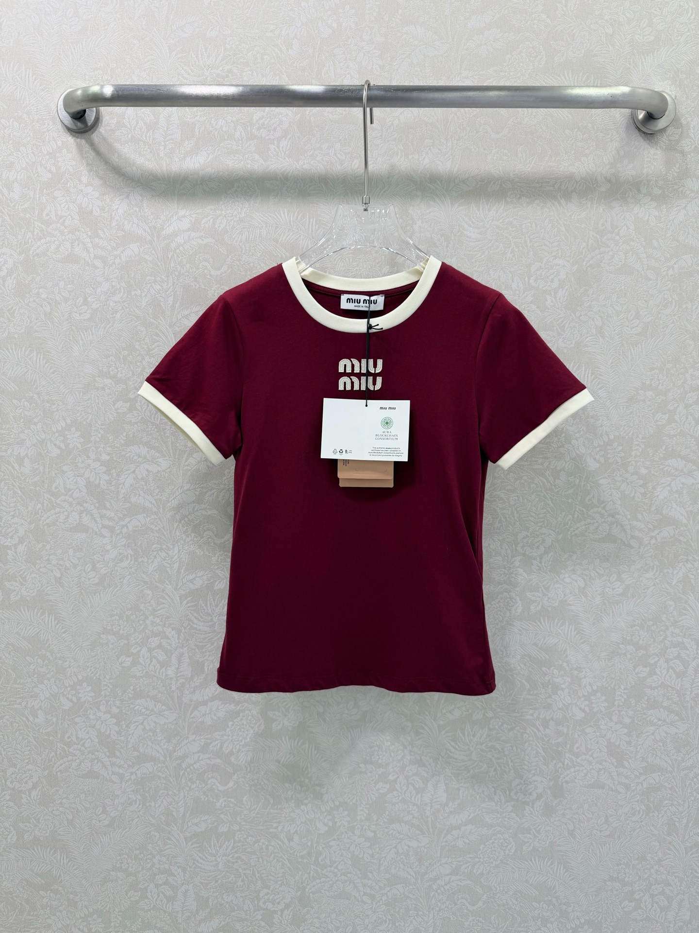 NO:721387,Miu Mi* 26Ss early spring new style, contrasting color round neck cotton short-sleeved T-shirt, top quality version!  The main color is retro burgundy, with off-white contrasting round collar and cuffs, creating a sweet element that is highly recognizable to the brand. Selected high-quality cotton fabrics are soft and breathable to the touch, and have excellent skin-friendliness; slim tailoring fits the body shape, not tight and looks neater. Three-dimensional Lo on the chest  go embroidery craftsmanship is exquisite, injecting light luxury texture into basic T-shirts. It is a versatile item for daily wear and styling in early spring. Available in stock SMLB, Miu Miu-clothing, miumiu, T-shirt, tees, t-shirt,19860909Miu Mi* 26Ss早春新款 撞色圆领棉质短袖T恤 顶级高版出品！以复古酒红为主调,搭配米白色撞色圆领与袖口,打造出极具品牌辨识度的甜美元素.精选优质棉质面料,触感柔软透气,亲肤性极佳；修身剪裁贴合身形,不紧绷更显利落.胸前立体logo刺绣工艺精致,为基础款T恤注入轻奢质感,是早春日常穿搭与造型搭配的百搭单品.现货发售SMLB,缪缪-服装,miumiu,T-shirt,tees，t-shirt,,Women's clothing