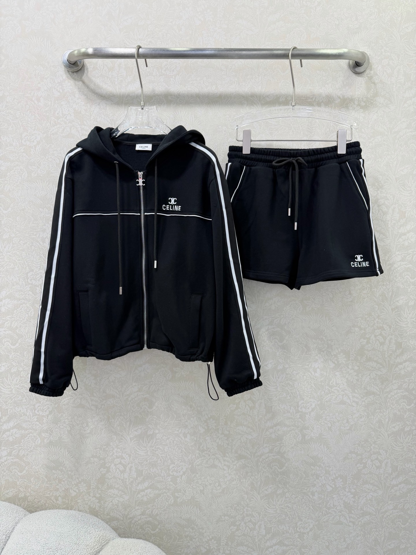 NO:743775,CELIN*26 New Ribbon Contrast Color Casual Sports Suit  The solid color base is paired with retro red stripes, and comes with a fresh and energetic filter, which is visually clean and reduces age. The high-weight terry cotton fabric is selected, soft and skin-friendly, breathable and not sweaty, making it comfortable to wear in spring and summer. The hooded zipper jacket is short-cut and paired with elastic cuffed sleeves, which is neat and energetic; the shorts of the same series are designed with a high-waist drawstring to easily optimize body proportions.  The brand's embroidered logo on the chest and side of the pants shows quality in a low-key manner. You don't need to worry about matching the whole outfit to create a casual and fashionable sports style, suitable for daily outings, leisure sports and other scenes. 2 colors and 3 codes SMLW, Celine-clothing, celine, celine, shorts, jackets  & coats,hats,19860909CELIN*26新款织带撞色休闲运动套装 纯色基底搭配复古红条,自带清新元气滤镜,视觉上干净又减龄.精选高克重毛圈棉面料,软糯亲肤,透气不闷汗,春夏穿着舒适自在.连帽拉链外套采用短款剪裁,搭配松紧收口袖,利落显精神；同系列短裤为高腰抽绳设计,轻松优化身材比例.胸前与裤侧的品牌刺绣logo,低调彰显品质,整套穿搭无需费心搭配,即可打造随性又时髦的运动风造型,适配日常出街、休闲运动等多种场景.2色3码SMLW,赛琳-服装,celine,celine,shorts,jackets & coats,hats,,Women's clothing