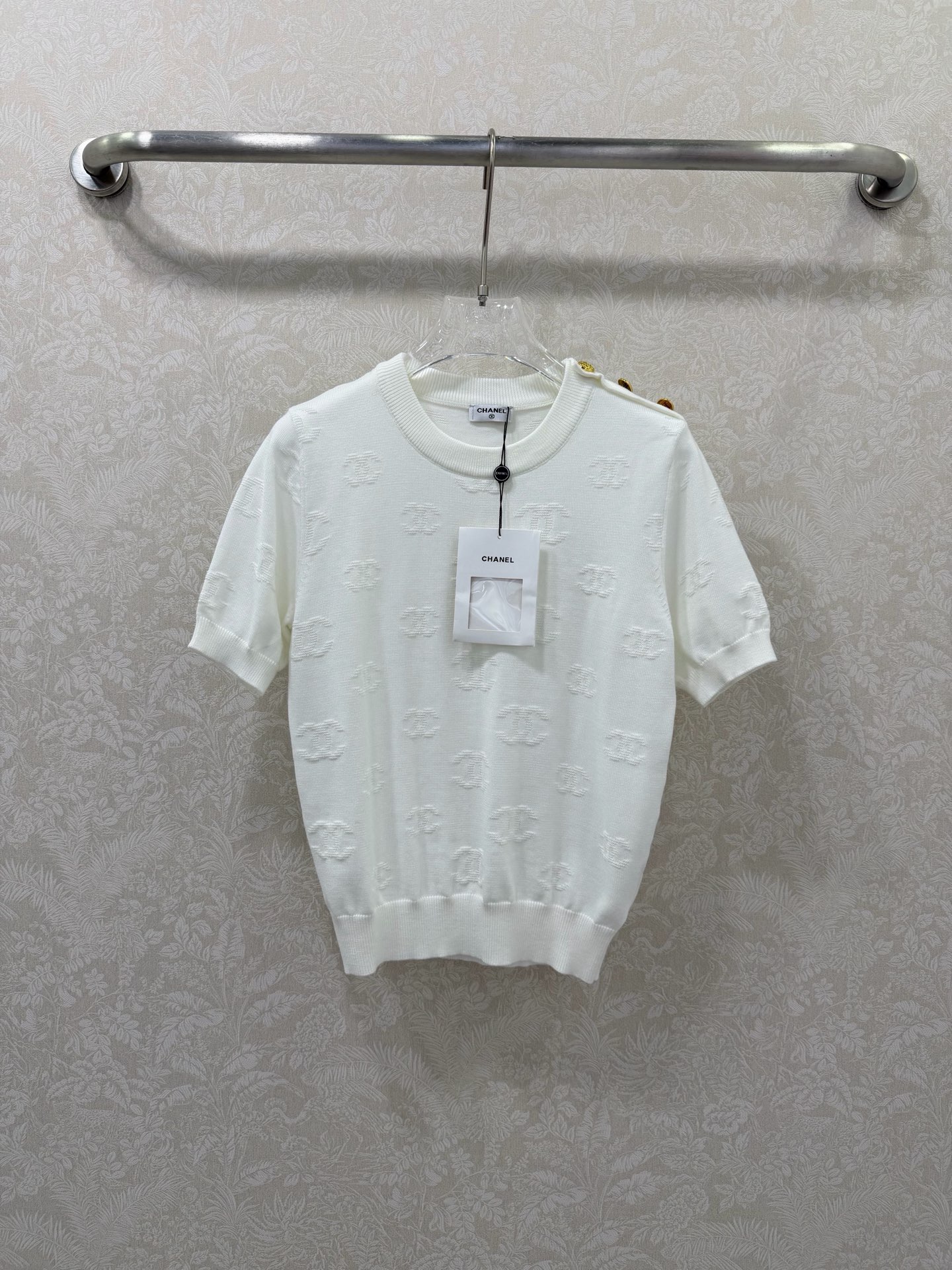 NO:744734,chan*l 26 new double C jacquard knitted short-sleeved top. Round neck knitted short-sleeved top. It is designed with the classic double C dark jacquard as the core. The three-dimensional double C dark jacquard is printed all over the body. It is low-key and luxurious. It shows delicate texture under different lights and is highly recognizable.  The right shoulder is embellished with three custom-made double-C metal buttons, which are a classic small fragrance element. They are both decorative and can fine-tune the shoulder shape to enhance sophistication. Fitted with a slightly slim fit + ribbed edges (neckline, cuffs, hem), it fits the body shape without being tight, can modify the waistline, and is suitable for a variety of body shapes. 2 colors and 3 sizes SMLPE, Chanel-clothing, chanel, chanel, loro piana, T-shirt,19860909chan*l 26新款双C提花针织短袖上衣 圆领针织短袖,以经典双C暗纹提花为核心设计,全身满印立体双C暗纹提花,低调奢华,在不同光线下呈现细腻肌理,辨识度极高. 右肩点缀三颗定制双c金属纽扣,是经典小香风元素,既作装饰又能微调肩型,提升精致度.合身微修身版型+罗纹收边（领口、袖口、下摆）,贴合身形不紧绷,能修饰腰线,适配多种身材.2色3码SMLPE,香奈儿-服装,chanel,chanel,loro piana,T-shirt,,Women's clothing