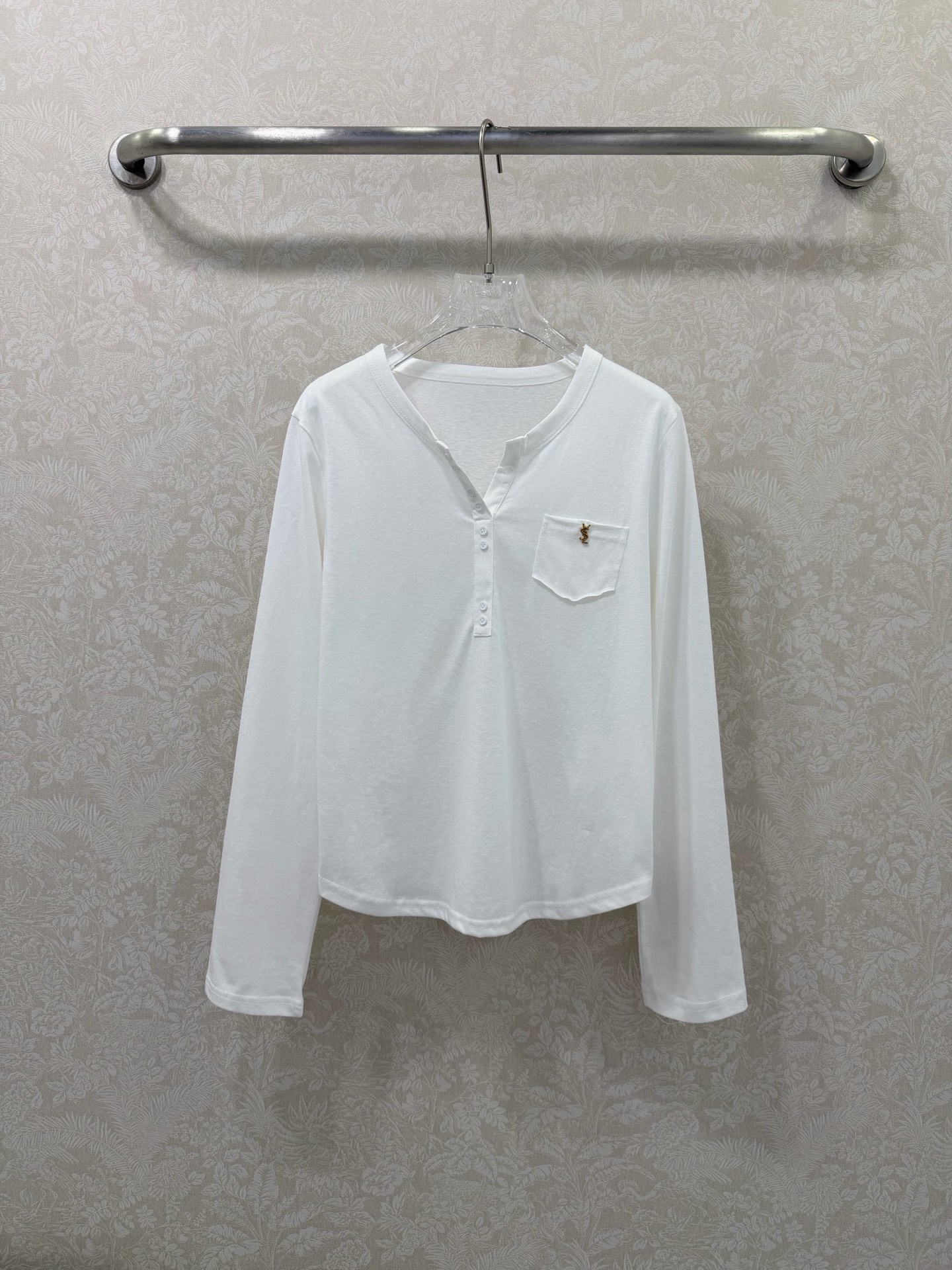 NO:744662,ysl 26 new henley collar pocket embroidered long-sleeved T-shirt  Simple and luxurious style Henley collar long-sleeved T-shirt, with detailed design to enhance the texture. Henley collar half placket + multiple button design, you can freely adjust the opening and closing of the neckline, modify the neck line, more refined and layered than ordinary round neck. The left chest pocket is equipped with a small ysl gold embroidery logo  , low-key and elegant, forming a visual highlight on a solid color base, enhancing the overall light and luxurious texture. The short and slightly loose version, just at the waistline, can optimize the body proportions, suitable for high-waisted bottoms, making you look taller and slimmer~Single color size 3 SMLR, Yves Saint Laurent-Clothing, saint  laurent, saint laurent, tees, t-shirt,19860909ysl 26新款亨利领口袋刺绣长袖T恤 简约轻奢风亨利领长袖T恤,以细节设计提升质感,亨利领半开襟+多颗纽扣设计,可自由调节领口开合度,修饰颈部线条,比普通圆领更具精致感与层次感.左胸口袋处配有ysl金色小刺绣标,低调显贵,在纯色基底上形成视觉亮点,提升整体轻奢质感.短款微宽松版型,刚好落在腰线位置,能优化身材比例,适配高腰下装,显高又显瘦~单色3码SMLR,圣罗兰-服装,saint laurent,saint laurent,tees，t-shirt,,Women's clothing