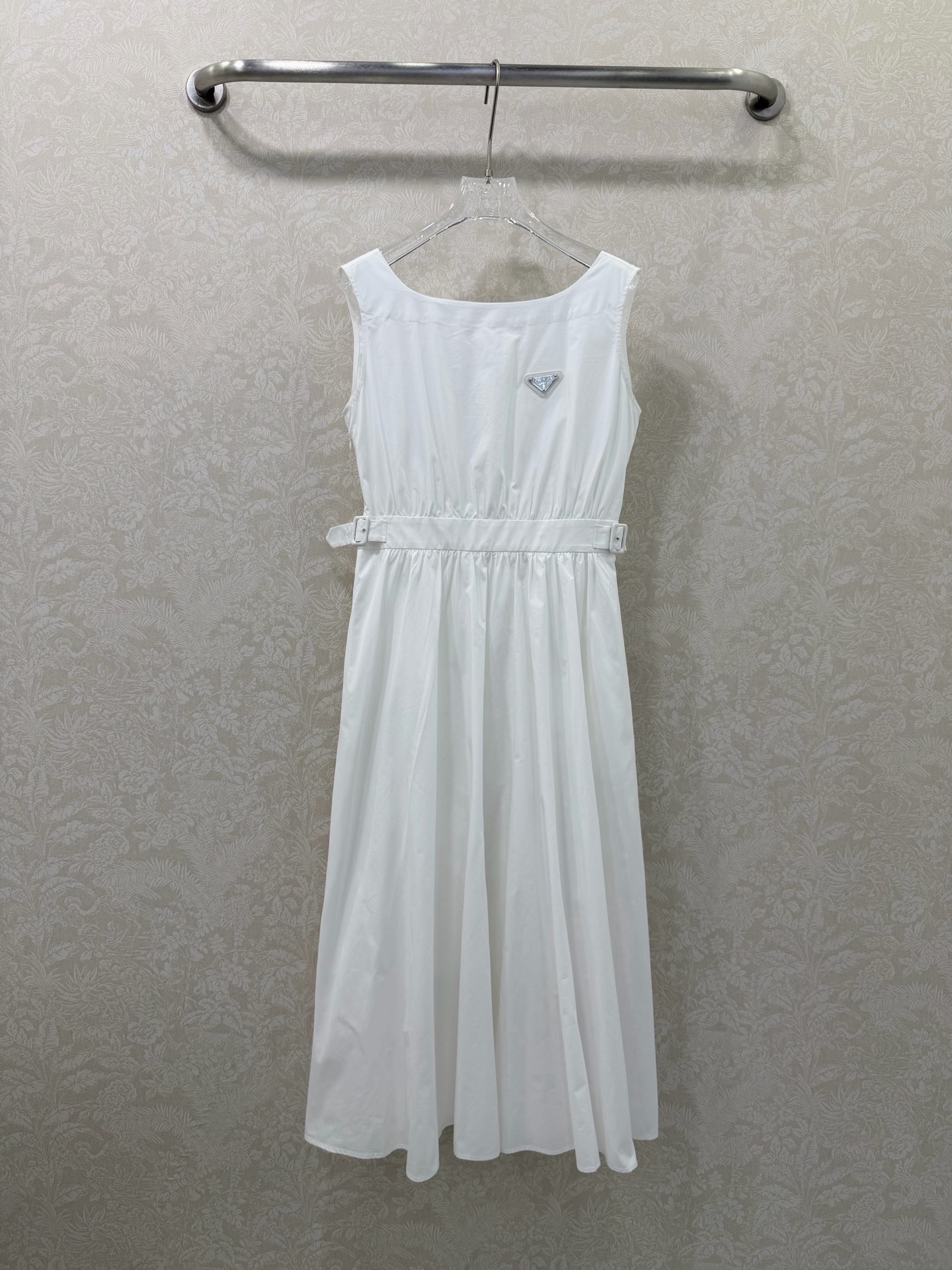 NO:744612,PRAD*26 new classic triangle logo sleeveless waist white dress  Sleeveless waist-cinching dress, with a classic triangle logo as the detail highlight on the chest. The square-neck sleeveless cut modifies the lines of the neck and shoulders, exposing the collarbone for a more lightweight look. The waist is equipped with an adjustable buckle to freely tighten the waistline, optimizing body proportions and creating an elegant X-shaped silhouette. A-line skirt with a high waist and wide hem, and a naturally draped hem.  Open, it effectively hides the fat on the crotch and thighs, makes it flexible and elegant when walking, and adapts to a variety of body shapes. The half-open button design on the back makes it easy to put on and take off, while adding design details to avoid monotony and bringing a sense of luxury ~ 2 colors and 3 codes SMLAW, Prada-clothing, prada, prada, skirts,19860909PRAD*26新款经典三角标无袖收腰白色连衣裙 无袖收腰连衣裙,胸前以经典三角标为细节亮点,方领无袖剪裁,修饰颈部与肩部线条,露出锁骨更显轻盈；腰侧配有可调节扣带,自由收束腰线,优化身材比例,打造优雅X型轮廓.高腰大摆A字裙型,裙摆自然垂坠散开,有效藏住胯部与大腿赘肉,走路时灵动飘逸,适配多种身材.后背半开纽扣设计,穿脱方便,同时增加设计细节,避免单调自带高级感~2色3码SMLAW,普拉达-服装,prada,prada,skirts,,Women's clothing