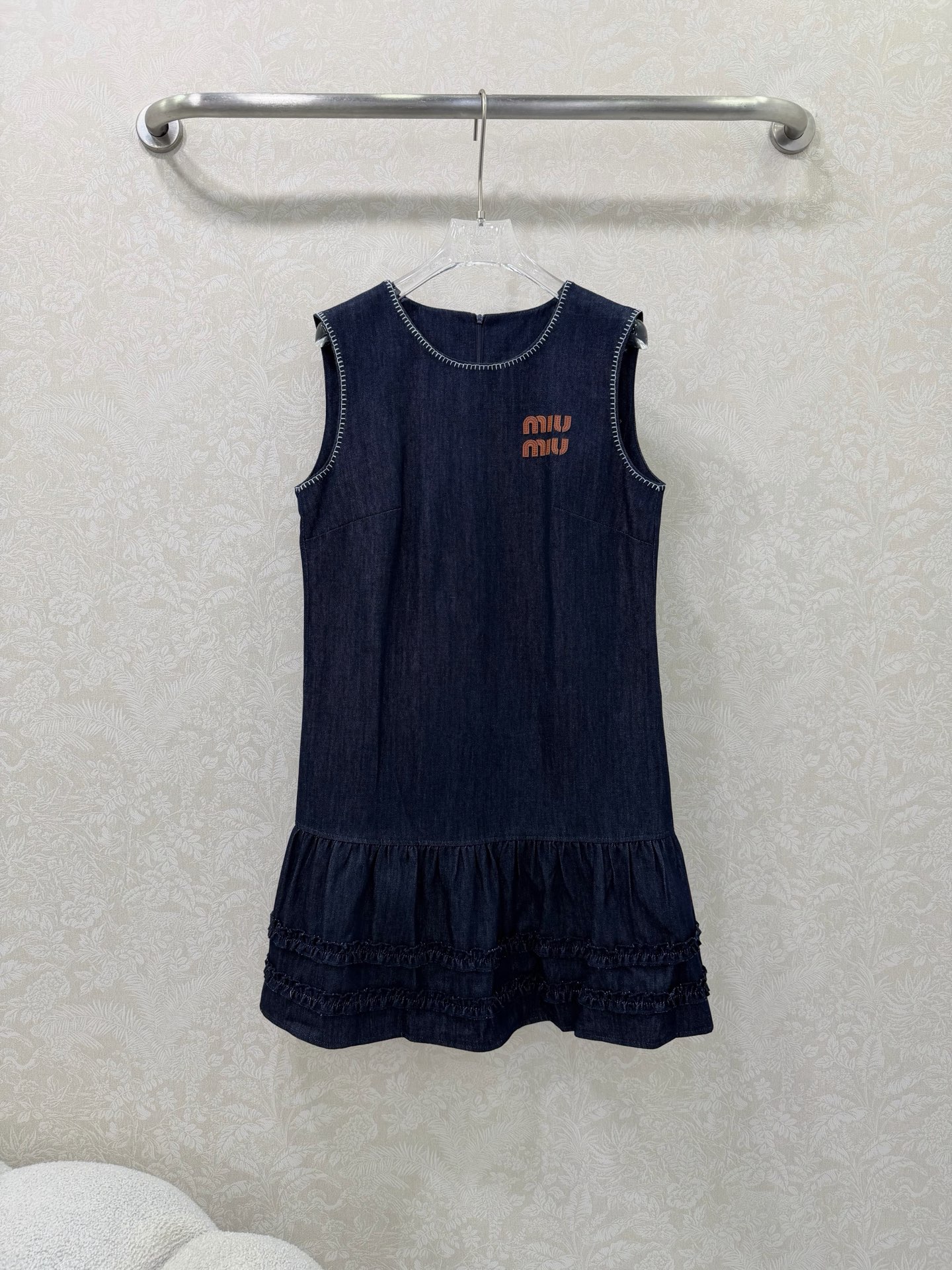 NO:755265,MiuMi*26 new sleeveless denim hem ruffled dress. Navy blue washed denim is crisp and slimming. The sleeveless A-line version covers the flesh and is tolerant, and is suitable for a variety of body types. The open-stitched edge on the neckline adds sophistication, and the brown double LOGO embroidery on the chest is highly recognizable. The hem has multi-layered ruffles + fungus edges, which is sweet and age-reducing. Miu has a girly style in Miu, which combines leisure and refinement. It is a popular sweet and cool item in spring and autumn. The taste of a rich daughter can be directly grasped.  Single color size 3 SMLAW, Miu Miu-clothing, miumiu, skirts,19860909MiuMi*26新款无袖牛仔下摆荷叶边连衣裙 藏青色水洗牛仔挺括显瘦,无袖A字版型遮肉包容,适配多种身材.领口明线锁边增精致感,胸前棕色双LOGO刺绣辨识度高,下摆多层荷叶边+木耳边,甜美减龄.Miu里miu气少女风,兼顾休闲与精致,是春秋季热门甜酷单品 富家千金那味儿直接拿捏 单色3码SMLAW,缪缪-服装,miumiu,skirts,,Women's clothing