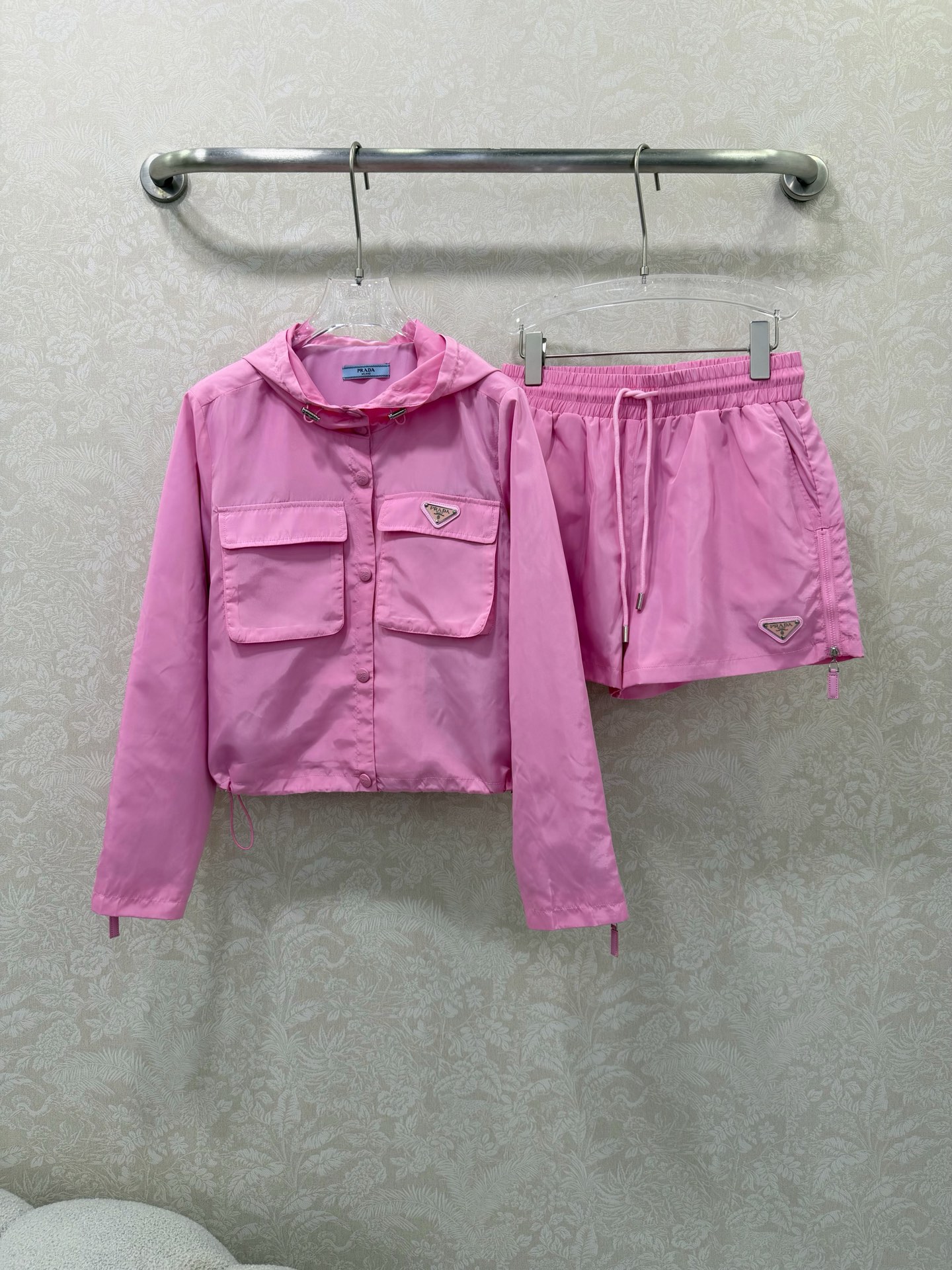 NO:755220,prad*26 new thin nylon suit!  The lightweight nylon fabric is smooth and crisp with a slight sheen. There are iconic triangle logos on the chest and trousers, and the metal texture is the finishing touch of the whole set. The double patch pockets on the chest of the jacket are practical and can add a workwear feel, making you feel instantly cool. The side zipper pockets of the shorts + zipper pullers of the same color combine beauty and practicality. They are breathable and not stuffy and can protect against sun and wind, so you can wear them in summer without any burden.  The hooded drawstring design has an adjustable brim, and the drawstring at the hem can be tightened freely, making it easy to switch between casual and waist-tightening styles. The effect of hiding flesh is first-class, sweet and cool!  This pink and black suit is so summer-friendly, right? The short style and high-waist cut directly stretch the body proportions into 30-70 points, making the legs look really long!  Color code 3 SMLWU, Prada-clothing, prada, prada, shorts, jackets & coats, hats,19860909prad*26新款薄款尼龙套装！ 轻薄尼龙面料顺滑挺括自带微微光泽感,胸口和裤身都有标志性三角徽标,金属质感拉满,是整套的灵魂点睛之笔 外套胸前双贴袋,实用又能增加工装感,酷感瞬间up ,短裤侧边拉链口袋+同色系拉链头,兼顾美观与实用性,透气不闷还能防晒防风,夏天穿毫无负担 连帽抽绳设计帽檐可调节,下摆抽绳可自由收紧,轻松切换随性/收腰两种版型, 藏肉效果一流甜酷双杀！这套粉黑套装也太懂夏天了吧 短款+高腰剪裁 直接把身材比例拉成三七分,显腿长到犯规！色3码SMLWU,普拉达-服装,prada,prada,shorts,jackets & coats,hats,,Women's clothing