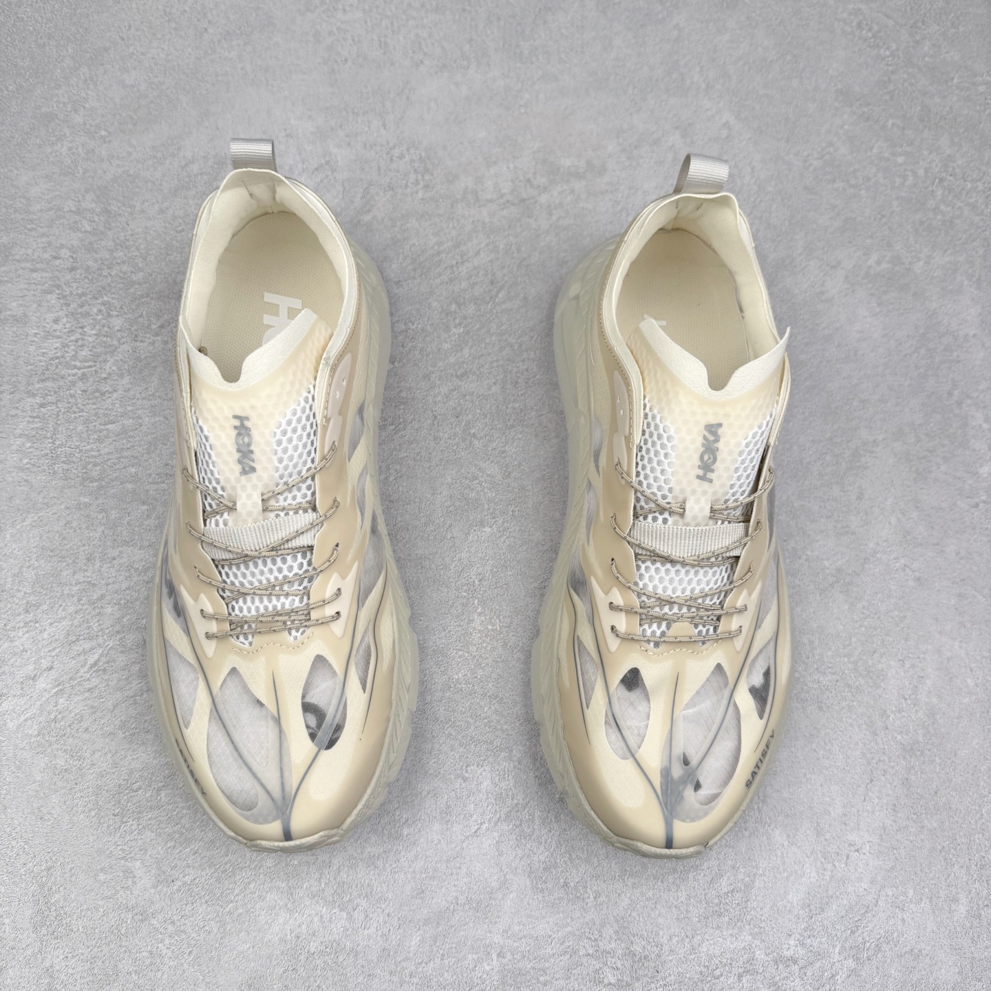 图片[2]-＃特价福利 Satisfy x HOKA ONE ONE 百搭简约防滑耐磨低帮跑步鞋 联名配色 球鞋继承了HOKA的经典越野鞋型MAFATE SPEED 4的设计，更在此基础上进行了创新和提升，使得它既适合户外越野跑，又充满了时尚潮流的元素。它的半透明鞋面设计，不仅让鞋身看起来更加轻便，而且提供了良好的透气性。而保护性的防撕裂尼龙面料，则确保了在复杂地形中的耐用性。这样的设计，让人在享受奔跑的同时，也能感受到鞋底带来的舒适。双层ProFly™中底的使用，是这款鞋的另一个亮点。这种中底材质，提供了卓越的缓震性能，无论是在崎岖的山路上，还是在平坦的道路上，都能给跑者带来稳定的支撑。而VIBRAM MEGAGRIP®及LITEBASE®大底的搭载，更是让这款鞋在保持高抓地力的同时，减轻了鞋底的重量，使得每一步跑动都轻盈如飞。尺码：36 36.5 37.5 38 38.5 39 40 40.5 41 42 42.5 43 44 45-选品中心