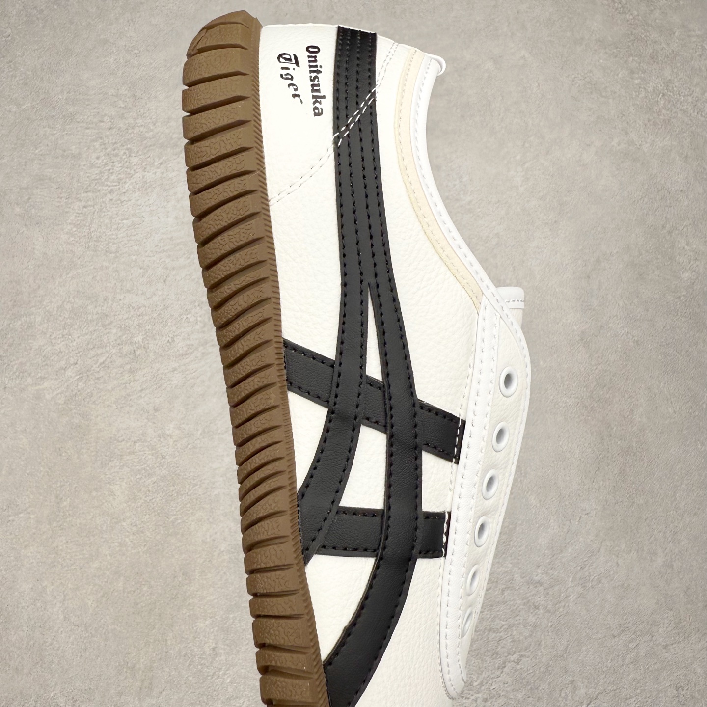 图片[6]-Onitsuka Tiger鬼塚虎 Tsunahiki Slip-on 舒适百搭 防滑耐磨平衡轻便包裹性支撑回弹透气 低帮 生活休闲鞋 男女同款 虎爪造型的logo，鞋身稳定包裹系统，支撑鞋身。一脚蹬无鞋带设计，休闲时尚，穿着舒适。Onitsuka Tiger特有的橡胶配方，弹性及止滑效果良好。鞋子外侧品牌logo标志，从视觉上感受品牌的个性，提升品牌的认知度。牛皮革帮面韧性佳，透气性好，耐磨性高。Onitsuka Tiger鬼塚虎从运动中汲取灵感，并致力于打造融合舒适感受与创新设计的时尚品牌。品牌的设计风格既体现了对传统的致敬，同时也表达了对精致风格和现代创意的推崇。我们提供独具个性的全系列产品，打造从头到脚的整体穿搭。每件产品皆以精湛工艺匠心打造，细节考究，品质出众。 时尚品牌OnitsukaTiger鬼塚虎不断呈献富于现代气息的系列单品，巧妙结合经典传承与锐意创新，并融蕴时尚格调与运动风范。1949年，鬼塚喜八郎（Kihachiro Onitsuka）创立了Onitsuka有限公司，即ASICS的前身。该品牌自成立之初便以促进青少年健康为已任，一以贯之，终令OnitsukaTigerStripes成为世界知名运动品牌的代名词。如今，这一传奇仍在日本传统和现代美学的融合中延续。从历久弥新的经典造型，到别具一格的新颖风格，通过与志同道合的艺术家、文化鉴赏家合作 OnitsukaTiger鬼塚虎的每一款鞋履、服装和配饰都回荡着品牌精神。尺码：36 37 37.5 38 39 39.5 40 40.5 41.5 42 42.5 43.5 44 45-选品中心