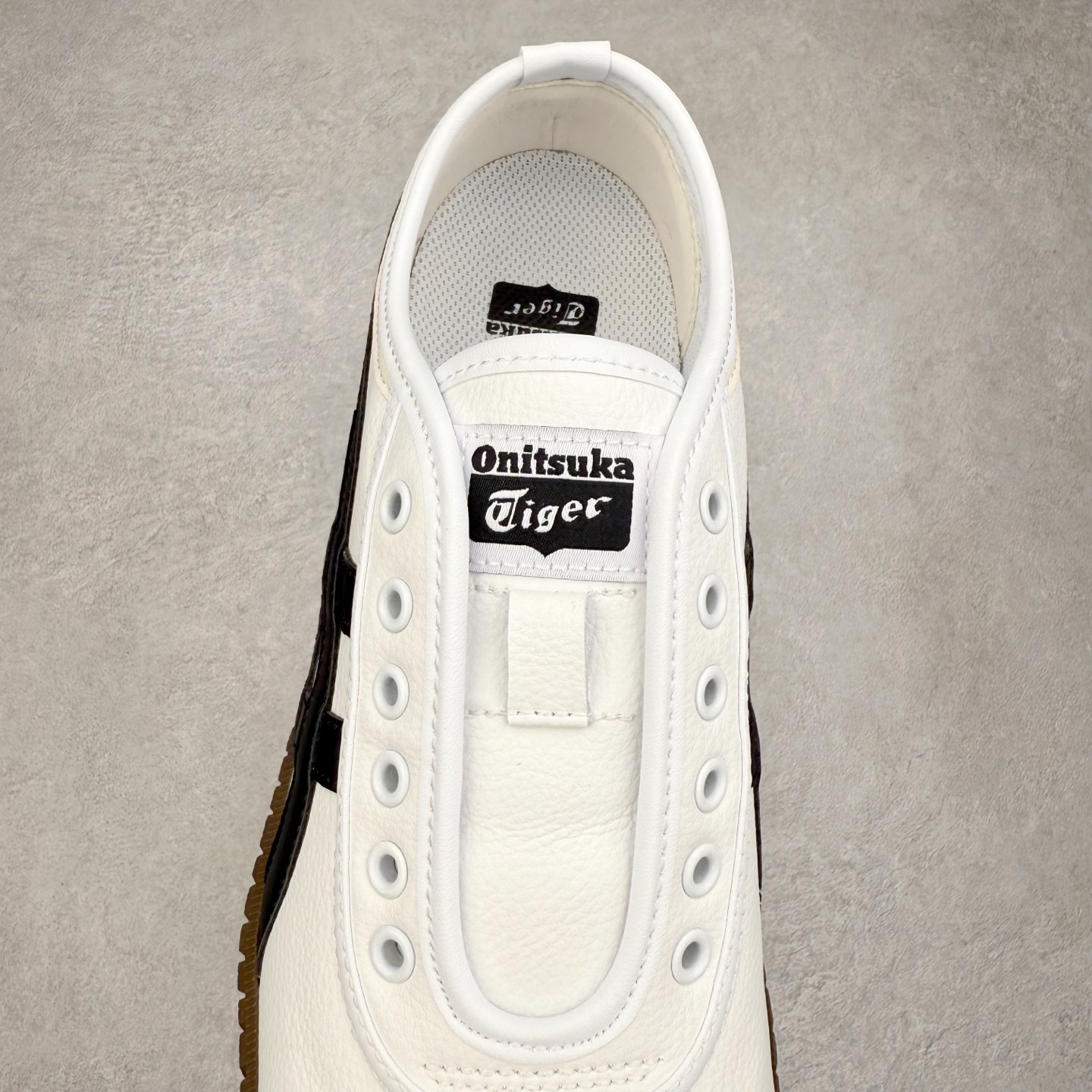 图片[5]-Onitsuka Tiger鬼塚虎 Tsunahiki Slip-on 舒适百搭 防滑耐磨平衡轻便包裹性支撑回弹透气 低帮 生活休闲鞋 男女同款 虎爪造型的logo，鞋身稳定包裹系统，支撑鞋身。一脚蹬无鞋带设计，休闲时尚，穿着舒适。Onitsuka Tiger特有的橡胶配方，弹性及止滑效果良好。鞋子外侧品牌logo标志，从视觉上感受品牌的个性，提升品牌的认知度。牛皮革帮面韧性佳，透气性好，耐磨性高。Onitsuka Tiger鬼塚虎从运动中汲取灵感，并致力于打造融合舒适感受与创新设计的时尚品牌。品牌的设计风格既体现了对传统的致敬，同时也表达了对精致风格和现代创意的推崇。我们提供独具个性的全系列产品，打造从头到脚的整体穿搭。每件产品皆以精湛工艺匠心打造，细节考究，品质出众。 时尚品牌OnitsukaTiger鬼塚虎不断呈献富于现代气息的系列单品，巧妙结合经典传承与锐意创新，并融蕴时尚格调与运动风范。1949年，鬼塚喜八郎（Kihachiro Onitsuka）创立了Onitsuka有限公司，即ASICS的前身。该品牌自成立之初便以促进青少年健康为已任，一以贯之，终令OnitsukaTigerStripes成为世界知名运动品牌的代名词。如今，这一传奇仍在日本传统和现代美学的融合中延续。从历久弥新的经典造型，到别具一格的新颖风格，通过与志同道合的艺术家、文化鉴赏家合作 OnitsukaTiger鬼塚虎的每一款鞋履、服装和配饰都回荡着品牌精神。尺码：36 37 37.5 38 39 39.5 40 40.5 41.5 42 42.5 43.5 44 45-选品中心