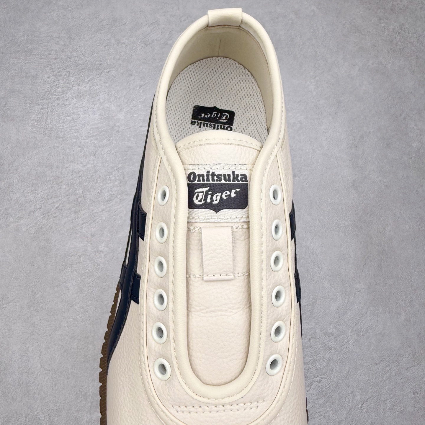 图片[5]-Onitsuka Tiger鬼塚虎 Tsunahiki Slip-on 舒适百搭 防滑耐磨平衡轻便包裹性支撑回弹透气 低帮 生活休闲鞋 男女同款 虎爪造型的logo，鞋身稳定包裹系统，支撑鞋身。一脚蹬无鞋带设计，休闲时尚，穿着舒适。Onitsuka Tiger特有的橡胶配方，弹性及止滑效果良好。鞋子外侧品牌logo标志，从视觉上感受品牌的个性，提升品牌的认知度。牛皮革帮面韧性佳，透气性好，耐磨性高。Onitsuka Tiger鬼塚虎从运动中汲取灵感，并致力于打造融合舒适感受与创新设计的时尚品牌。品牌的设计风格既体现了对传统的致敬，同时也表达了对精致风格和现代创意的推崇。我们提供独具个性的全系列产品，打造从头到脚的整体穿搭。每件产品皆以精湛工艺匠心打造，细节考究，品质出众。 时尚品牌OnitsukaTiger鬼塚虎不断呈献富于现代气息的系列单品，巧妙结合经典传承与锐意创新，并融蕴时尚格调与运动风范。1949年，鬼塚喜八郎（Kihachiro Onitsuka）创立了Onitsuka有限公司，即ASICS的前身。该品牌自成立之初便以促进青少年健康为已任，一以贯之，终令OnitsukaTigerStripes成为世界知名运动品牌的代名词。如今，这一传奇仍在日本传统和现代美学的融合中延续。从历久弥新的经典造型，到别具一格的新颖风格，通过与志同道合的艺术家、文化鉴赏家合作 OnitsukaTiger鬼塚虎的每一款鞋履、服装和配饰都回荡着品牌精神。尺码：36 37 37.5 38 39 39.5 40 40.5 41.5 42 42.5 43.5 44 45-选品中心