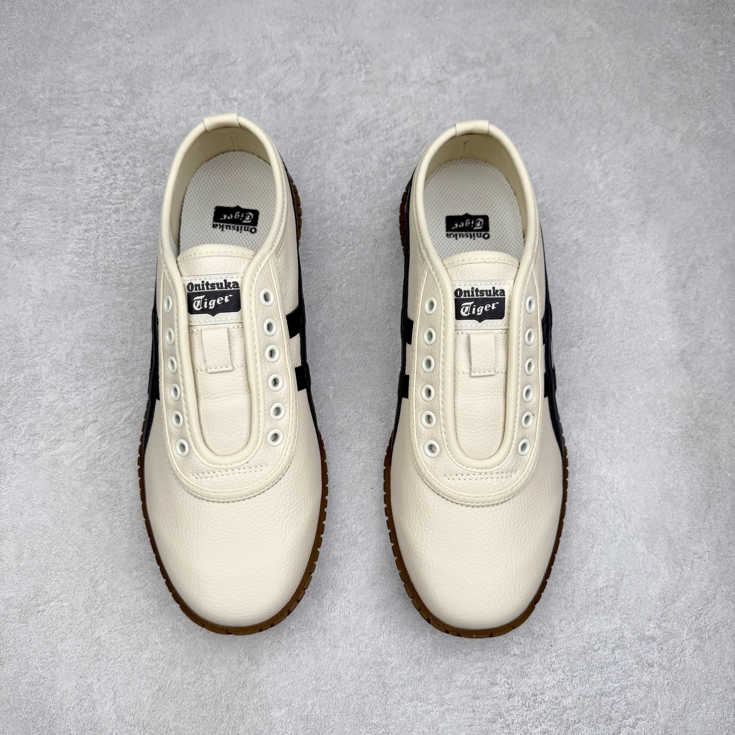图片[2]-Onitsuka Tiger鬼塚虎 Tsunahiki Slip-on 舒适百搭 防滑耐磨平衡轻便包裹性支撑回弹透气 低帮 生活休闲鞋 男女同款 虎爪造型的logo，鞋身稳定包裹系统，支撑鞋身。一脚蹬无鞋带设计，休闲时尚，穿着舒适。Onitsuka Tiger特有的橡胶配方，弹性及止滑效果良好。鞋子外侧品牌logo标志，从视觉上感受品牌的个性，提升品牌的认知度。牛皮革帮面韧性佳，透气性好，耐磨性高。Onitsuka Tiger鬼塚虎从运动中汲取灵感，并致力于打造融合舒适感受与创新设计的时尚品牌。品牌的设计风格既体现了对传统的致敬，同时也表达了对精致风格和现代创意的推崇。我们提供独具个性的全系列产品，打造从头到脚的整体穿搭。每件产品皆以精湛工艺匠心打造，细节考究，品质出众。 时尚品牌OnitsukaTiger鬼塚虎不断呈献富于现代气息的系列单品，巧妙结合经典传承与锐意创新，并融蕴时尚格调与运动风范。1949年，鬼塚喜八郎（Kihachiro Onitsuka）创立了Onitsuka有限公司，即ASICS的前身。该品牌自成立之初便以促进青少年健康为已任，一以贯之，终令OnitsukaTigerStripes成为世界知名运动品牌的代名词。如今，这一传奇仍在日本传统和现代美学的融合中延续。从历久弥新的经典造型，到别具一格的新颖风格，通过与志同道合的艺术家、文化鉴赏家合作 OnitsukaTiger鬼塚虎的每一款鞋履、服装和配饰都回荡着品牌精神。尺码：36 37 37.5 38 39 39.5 40 40.5 41.5 42 42.5 43.5 44 45-选品中心