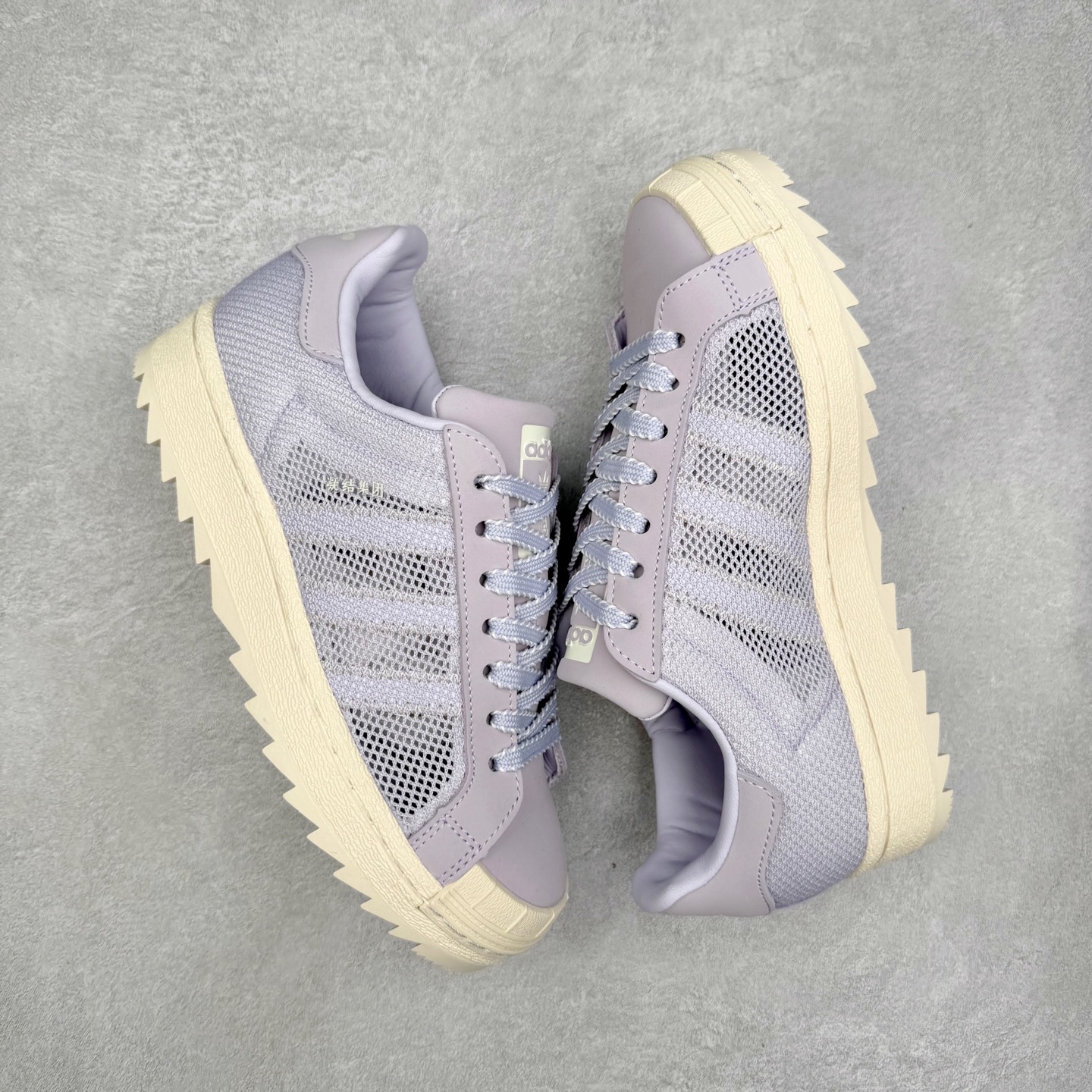 图片[3]-NBHD/NEIGHBORHOOD x CLOT x Adidas Originals Superstar PNS 贝壳头联名 锯齿底系列低帮百搭休闲运动板鞋 JS0891 AD Originals与陈冠希正式宣布成为全球合作伙伴，共同打造 Originals by Edison Chen系列。这一重要联合将开启重新定义创新精神和塑造文化传承的新时代。全球生活方式品牌CLOT迎来了成立20周年，陈冠希作为创始人兼创意总监，年轻时从温哥华移居香港，这段经历让他感受到了东西方文化的碰撞，拥有丰富的视角使他对东西方多元化有了更加深入的认识，并为创立CLOT打下了坚实的基础。对于此次合作，陈冠希凭借着他的思维视野和创意能力，结合adidas丰富的档案和历史，推出了一系列独家合作款式。CLOT 2024年春夏系列时装秀以“承前启后”为主题展开，寓意着品牌致力于培养新秀，延续以国际视野呈现中华文化，并将其创作带到全球的承诺。为进一步加强创意理念，CLOT创始人兼创意总监陈冠希特别邀请了著名时装设计师Humberto Leon，共同设计了本季度系列。该系列围绕三种截然不同的风格进行探索，包括正式、富有生活感和街头风格的服饰，呈现出既可以分别探索又能将三者融合的系列。其中还包括了adidas与陈冠希携手NEIGHBORHOOD共同推出的NEIGHBORHOOD CLOT SUPERSTAR BY EDISON CHEN三方联名鞋款，经过重新设计的标志性SUPERSTAR运动鞋以齿状鞋底和仿旧处理的半贝壳头结合形成独特的轮廓，鞋面网布下有反光装饰的三条纹细节，后跟部分同样点缀着带有反光装饰效果的“凝结集团”标志。adidas Originals by Edison Chen系列旨在体现品牌与陈冠希对创新精神的共同愿景。尺码：36 36⅔ 37⅓ 38 38⅔ 39⅓ 40 40⅔ 41⅓ 42 42⅔ 43⅓ 44 44⅔ 45-选品中心