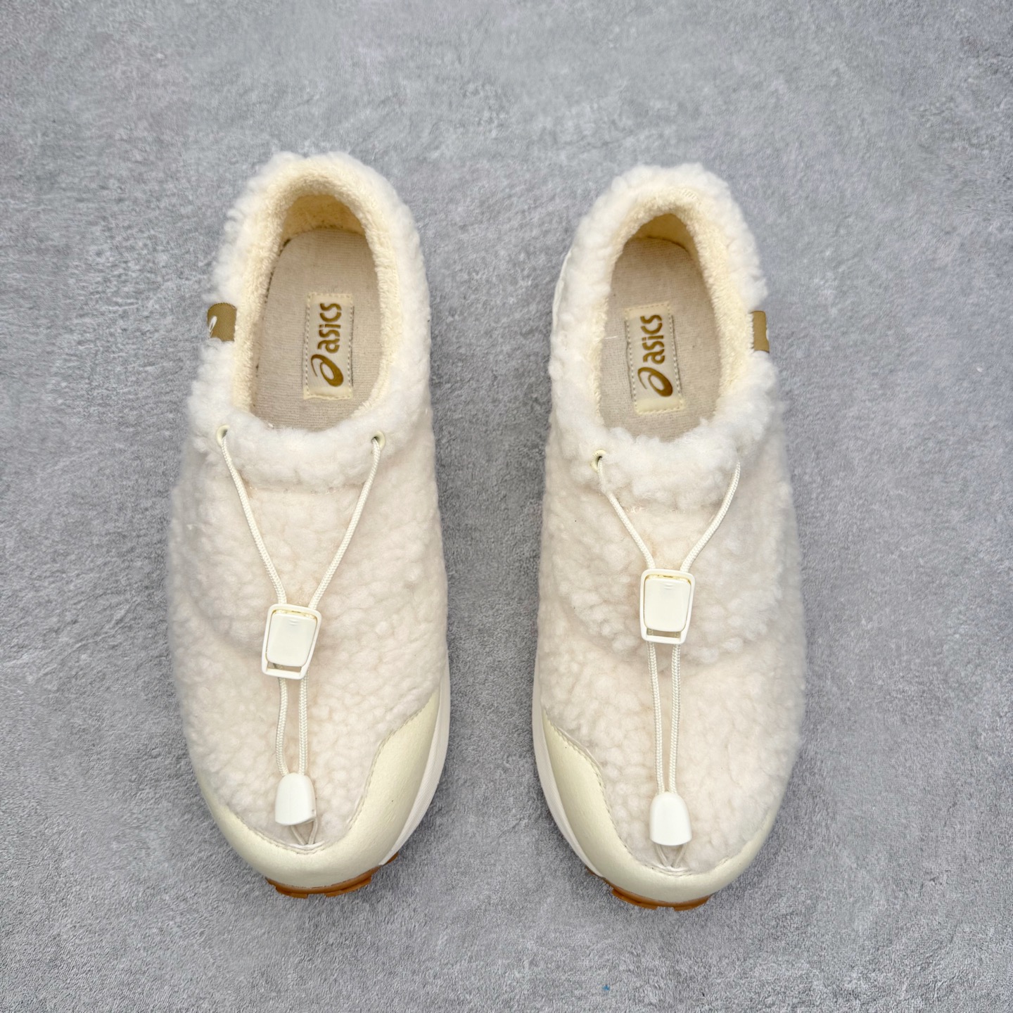 图片[2]-ASICS Gel-Sonoma WT 泰迪毛毛拖 时尚复古 一脚蹬 耐磨保暖 生活休闲鞋 男女同款 ASICS（亚瑟士）是日本实业家鬼冢喜八郎创立的跑鞋运动品牌，名字想法源自著名的拉丁谚语“AnimaSana In Corpore Sano”，意为“健全的精神寓于强健的体魄”。正如其名字的含义，ASICS亚瑟士一直坚信保持身体的健康与活力是打造健康快乐的生活方式的最佳途径。亚瑟士的跑鞋、篮球鞋等系列集专业与美貌于一身，拥有极高的热度。2016年，ASICS在“2016年日本最佳全球品牌”排行榜名列第17名。尺码：36 37 37.5 38 39 39.5 40 40.5 41.5 42 42.5 43.5 44 45-选品中心