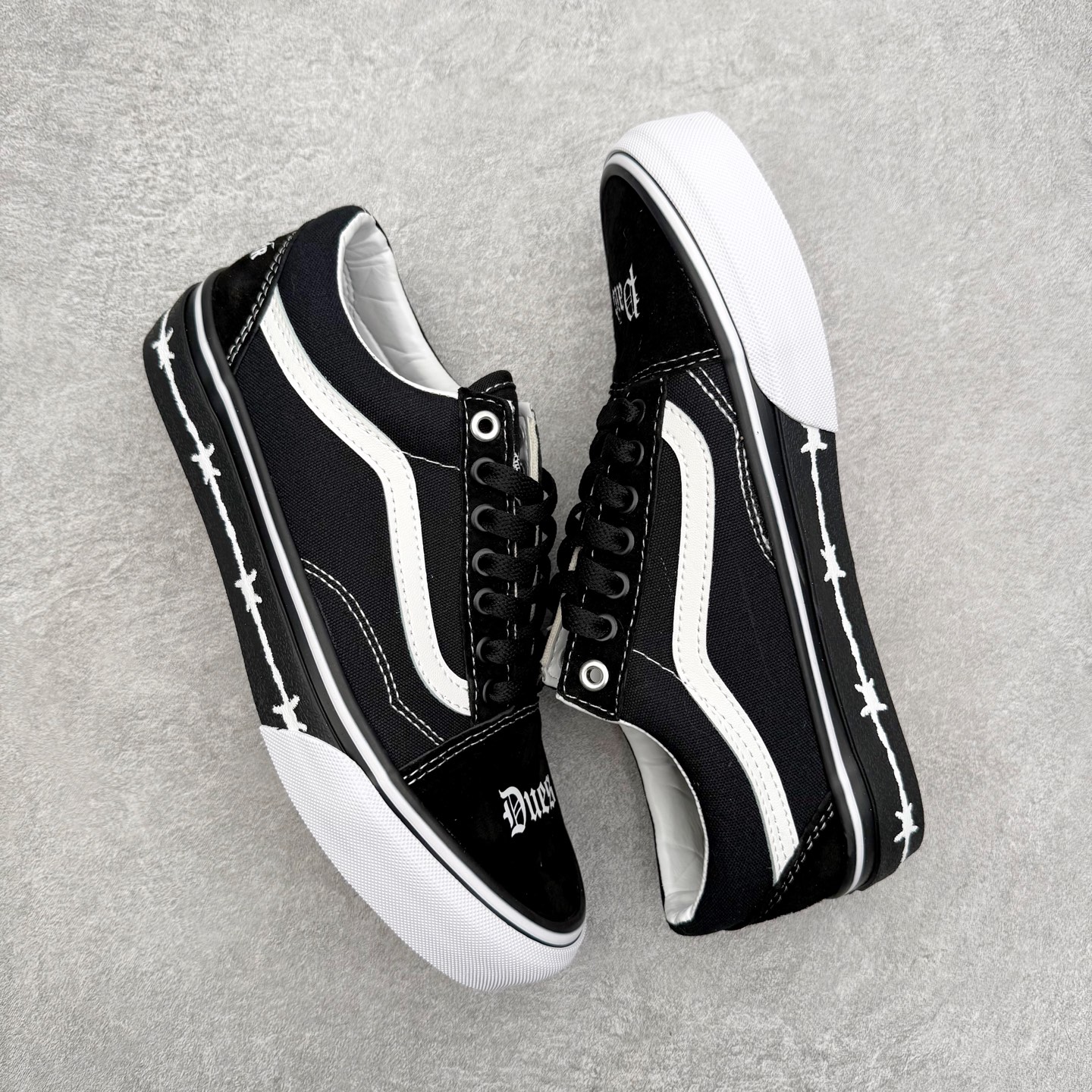 图片[3]-Vans x Travis Barker Old Skool 美国传奇鼓手 Travis Barker 与 Vans 联合推出的 Old Skool 鞋款，整体以暗黑风格设计，黑白色调非常简约。最吸引注目的是鞋头位置的以哥特字体，将\\\”Dues\\\”和 \\\”Paid\\\” 分印于两侧。黑色包边上则印有荆棘图案，各种黑白交织，为暗黑鞋款增添了层次感。 货号：VN000E9TMCG 尺码：35 36 36.5 37 38 38.5 39 40 40.5 41 42 42.5 43 44-选品中心