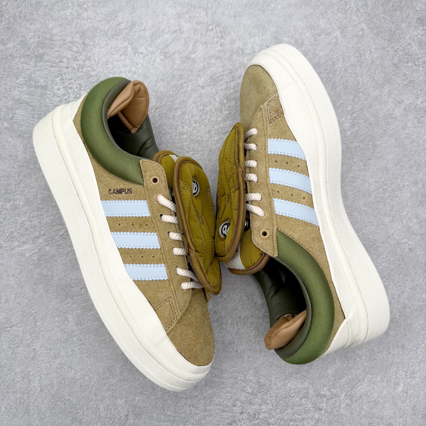 图片[3]-Bad Bunny x AD Campus Light 学院莱特系列低帮复古系带休闲运动板鞋 联名坏痞兔 ID7950 全套原楦原纸板原厂数据开发 原装进口翻毛皮料正确绒感卡色 正确铜制锁扣 原盒原配防尘袋配件 以云白色、米色与和做旧泛黄配色为基调 厚绒麂皮与奢华皮革环绕鞋面 正面看起来无比寻常 但从侧面可以发现双鞋舌和双鞋跟设计提升了观感 鞋中底的重新设计也使得存在感大大增加 更加切合当下时尚 鞋舌和鞋垫上带有 Bad Bunny 的专属标志 并且使用特殊包装彰显其身份 尺码：36 36⅔ 37⅓ 38 38⅔ 39⅓ 40 40⅔ 41⅓ 42 42⅔ 43⅓ 44 45-选品中心