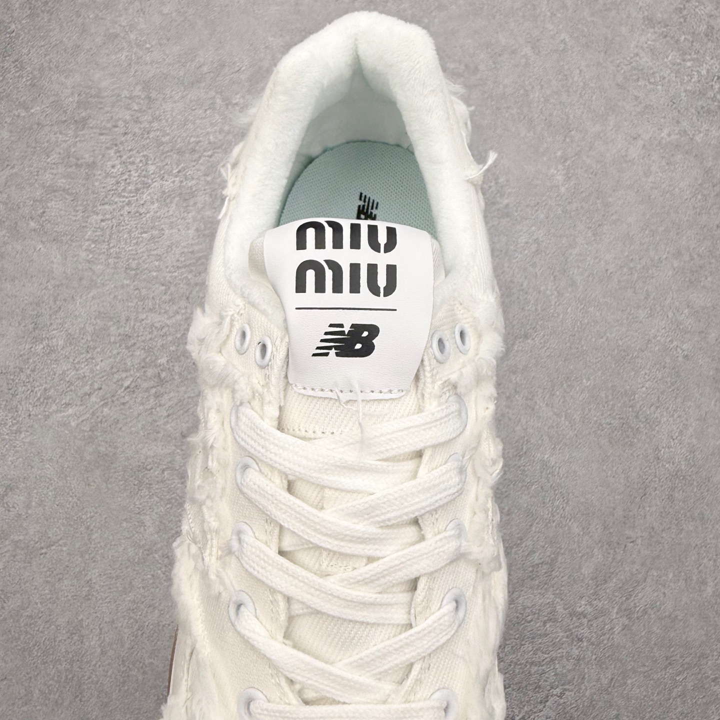 图片[5]-Miu Miu x New Balance NB574联名复古跑鞋 采用仿旧鞋面设计 侧边和鞋背部分 特意没有缝合布料与皮革 边缘散开的的毛边清晰可见 充分营造出仿旧风格的丹宁美感 鞋舌的部分也做了简单的修改 加入两者的 Logo 使风格并存 鞋底的部分选用生胶制作为鞋款添入复古元素 尺码：36/45-选品中心