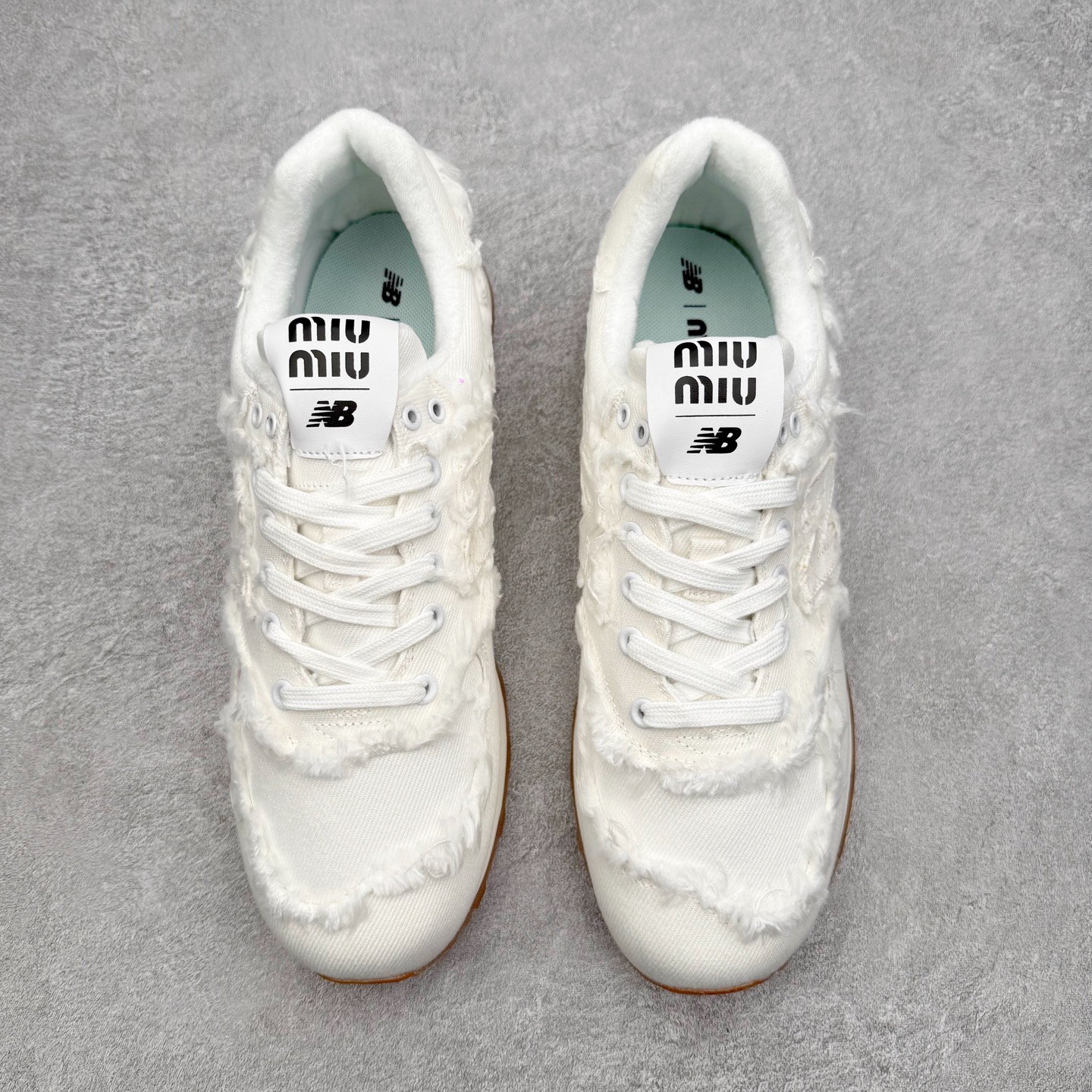 图片[2]-Miu Miu x New Balance NB574联名复古跑鞋 采用仿旧鞋面设计 侧边和鞋背部分 特意没有缝合布料与皮革 边缘散开的的毛边清晰可见 充分营造出仿旧风格的丹宁美感 鞋舌的部分也做了简单的修改 加入两者的 Logo 使风格并存 鞋底的部分选用生胶制作为鞋款添入复古元素 尺码：36/45-选品中心
