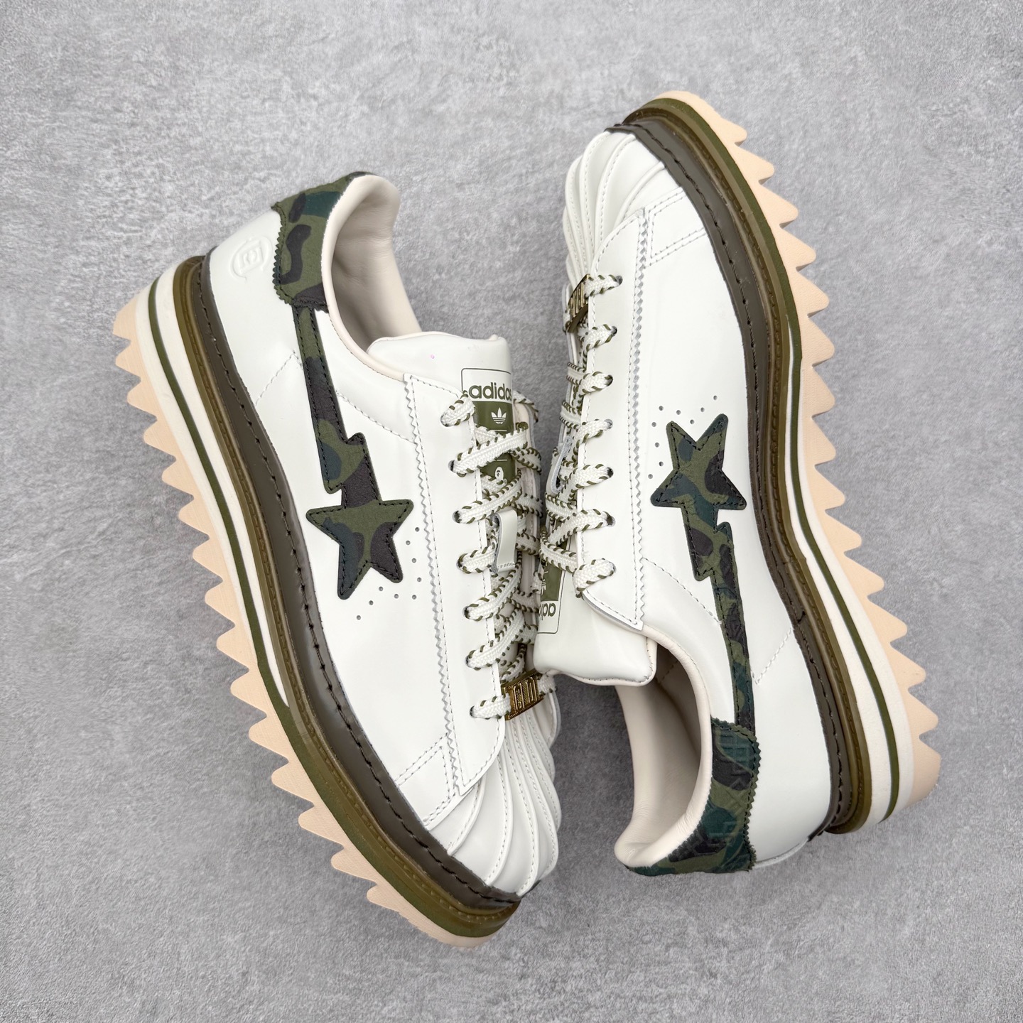 图片[3]-＃纯原 BAPE x CLOT x Superstar by EDISON CHEN 猿人头 凝结集团 陈冠希三方联名贝壳头KJ1473 以通体白色皮革材质和棕绿色鞋底线条打造，鞋面依旧是不对称鸳鸯的设计。鞋侧分别饰有BAPE STA Logo和阿迪达斯三条纹，搭配经典的Bape绿色迷彩图案和Clot中国风丝绸元素的压印标识呈现。鞋舌和鞋垫上上则分别点缀有CLOT x BAPE x 阿迪三方联名的标志，鞋带上也搭配金色CLOT和BAPE鞋带扣，后跟位置同样分别饰有BAPE和CLOT的品牌Logo，彰显特殊身份。实拍调校N版已经零色差零失真 百分百还原实物色彩所见即所得 不存在货不对板色差等低级问题 选购参考实物拍摄 不混卖不参货 只用心做好货严格选品 承诺混一赔十 尺码：36 36.5 37.5 38 38.5 39 40 40.5 41 42 42.5 43 44 44.5 45 46-选品中心