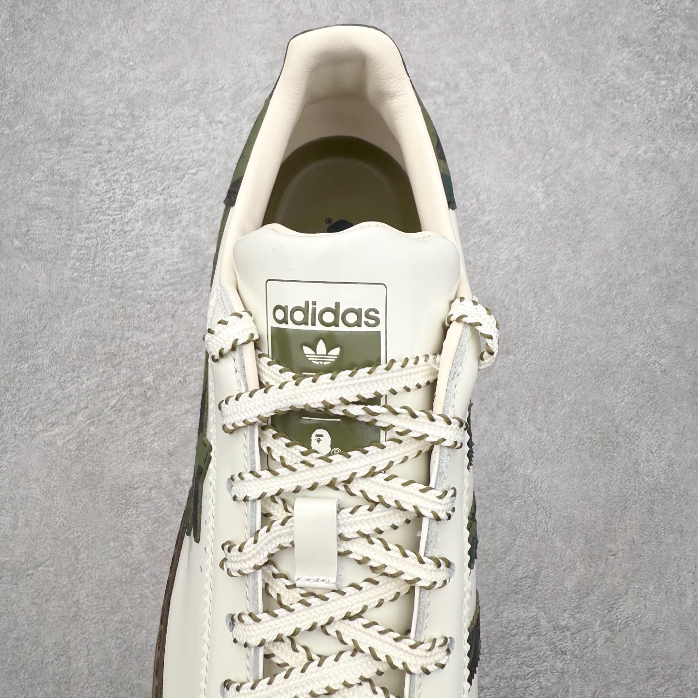 图片[5]-＃纯原 BAPE x CLOT x Superstar by EDISON CHEN 猿人头 凝结集团 陈冠希三方联名贝壳头KJ1473 以通体白色皮革材质和棕绿色鞋底线条打造，鞋面依旧是不对称鸳鸯的设计。鞋侧分别饰有BAPE STA Logo和阿迪达斯三条纹，搭配经典的Bape绿色迷彩图案和Clot中国风丝绸元素的压印标识呈现。鞋舌和鞋垫上上则分别点缀有CLOT x BAPE x 阿迪三方联名的标志，鞋带上也搭配金色CLOT和BAPE鞋带扣，后跟位置同样分别饰有BAPE和CLOT的品牌Logo，彰显特殊身份。实拍调校N版已经零色差零失真 百分百还原实物色彩所见即所得 不存在货不对板色差等低级问题 选购参考实物拍摄 不混卖不参货 只用心做好货严格选品 承诺混一赔十 尺码：36 36.5 37.5 38 38.5 39 40 40.5 41 42 42.5 43 44 44.5 45 46-选品中心