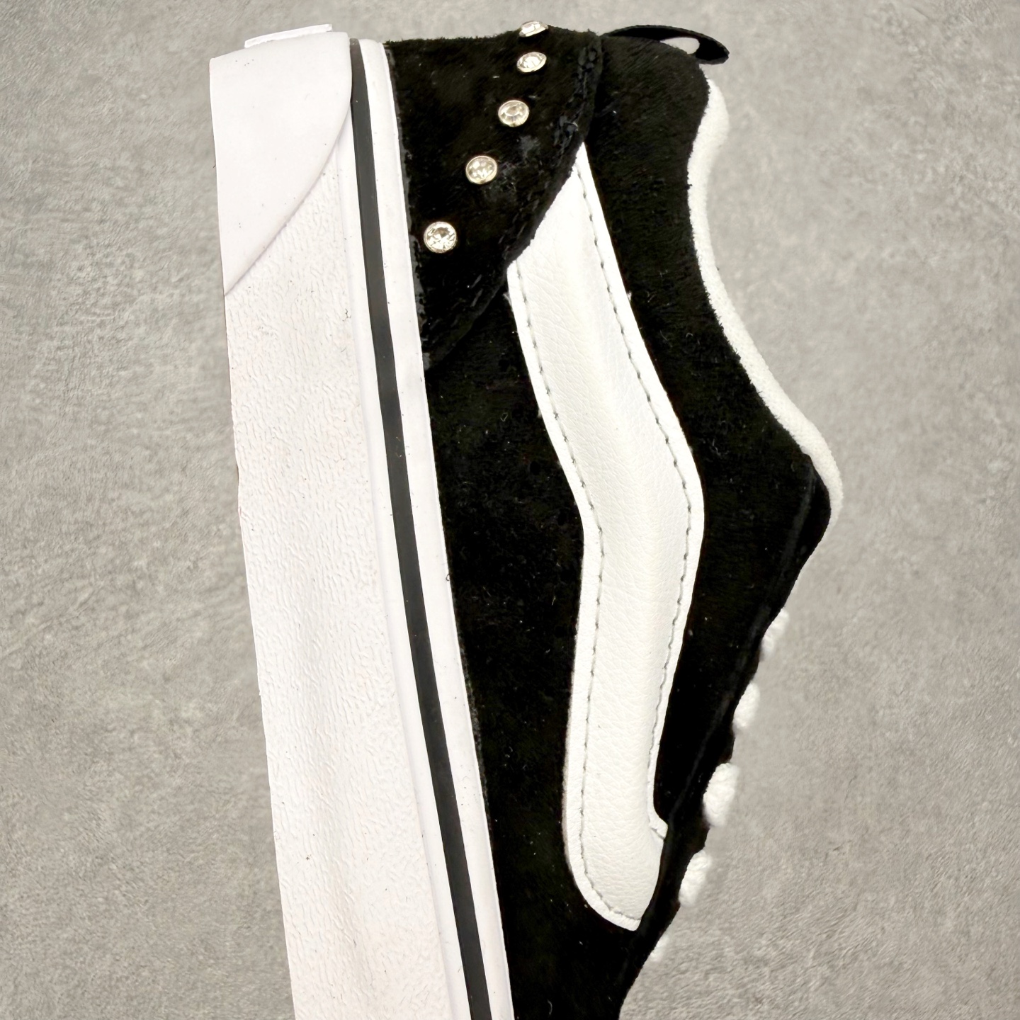 Vans Knu Skool 碎钻铆钉面包鞋此次以碎钻元素为设计亮点，黑白经典配色为基底，全麂皮鞋面搭配