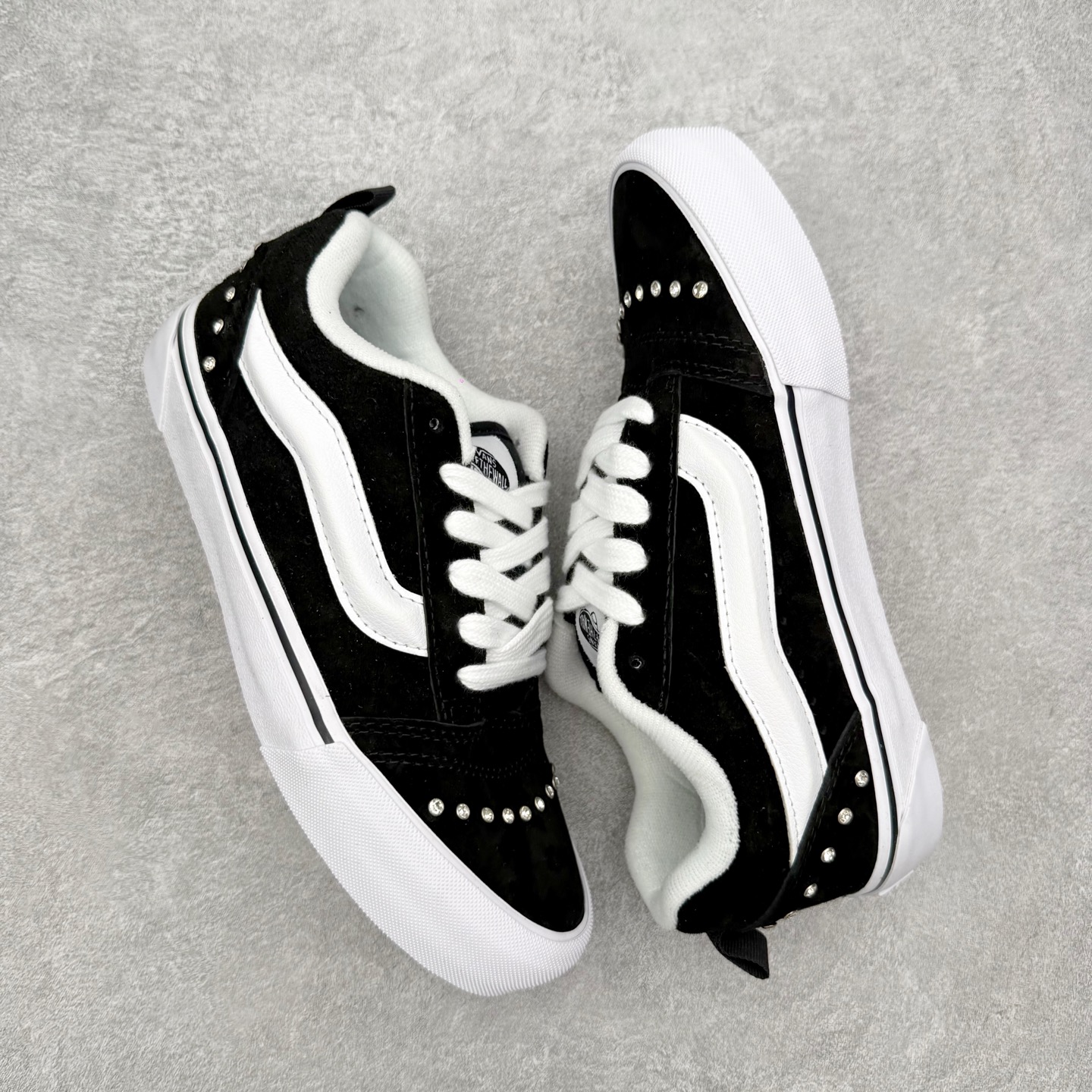 Vans Knu Skool 碎钻铆钉面包鞋此次以碎钻元素为设计亮点，黑白经典配色为基底，全麂皮鞋面搭配