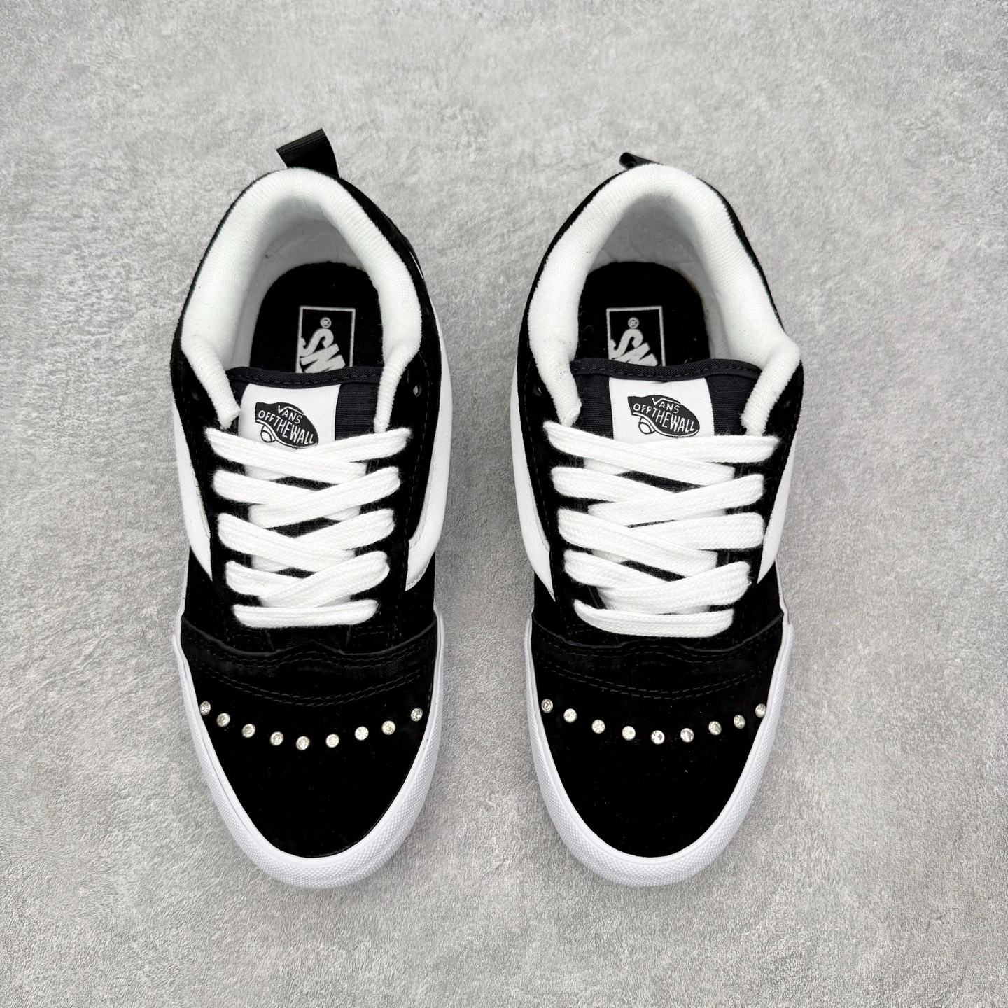 Vans Knu Skool 碎钻铆钉面包鞋此次以碎钻元素为设计亮点，黑白经典配色为基底，全麂皮鞋面搭配