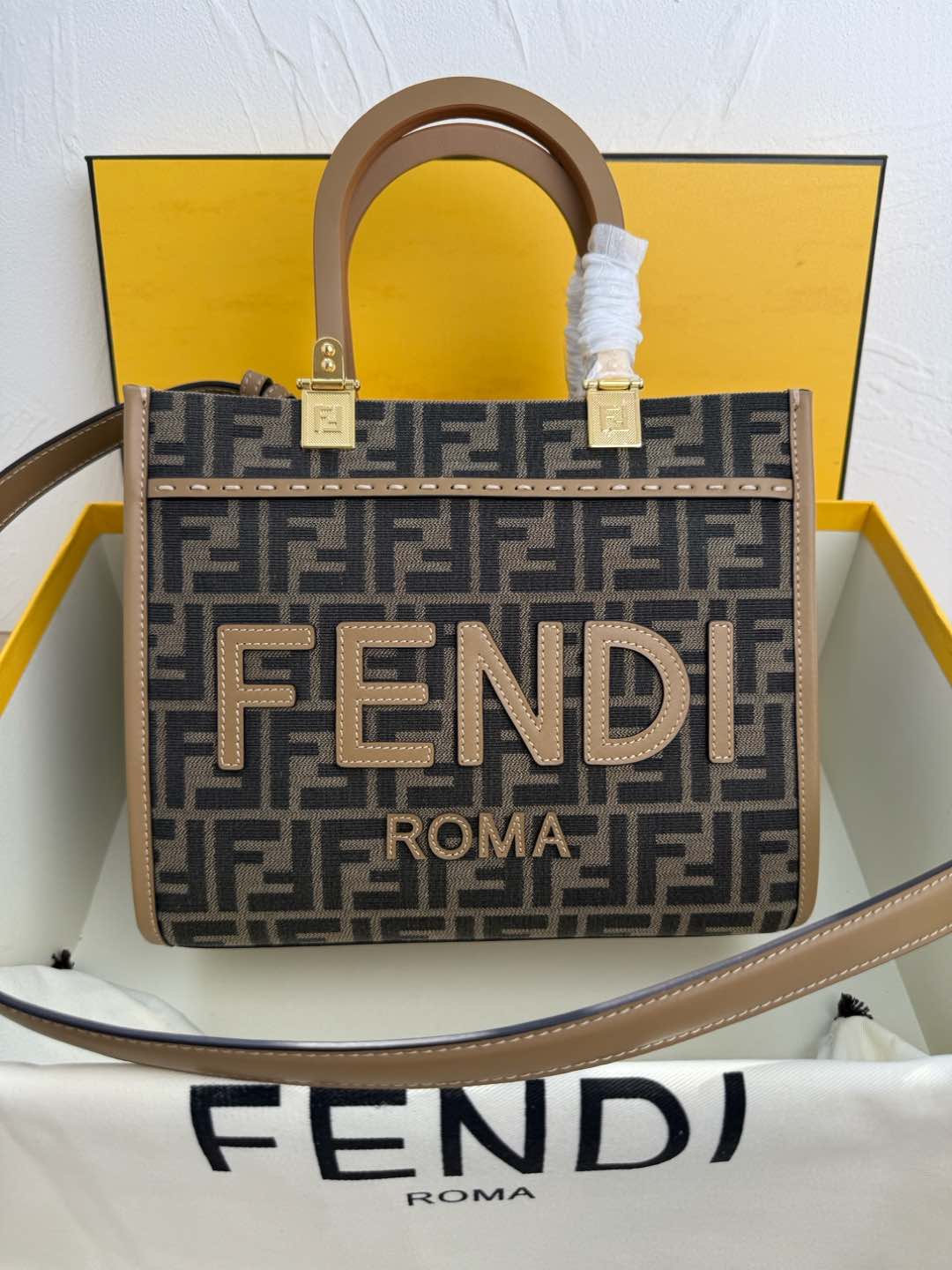 NO:203822,Small In stock Sunshine small tote bag, fabric material, decorated with FF pattern jacquard, sand and stone color FEND1 ROMA leather lettering. Sand and stone color plexiglass hard handle. Features spacious inner compartment with inner lining, sand and stone color leather edges and gold metal parts. Equipped with two handles and removable shoulder straps, for hand or shoulder shoulder. 8042S size 22.5*25.5*12cm, Fendi, fendi, fendi19860909小号 现货供应 Sunshine小号手提袋,布料材质,饰有FF图案提花,沙石色FEND1 ROMA皮质字样.沙石色有机玻璃硬质手柄.设有宽敞的带内衬内部隔层,沙石色皮革边缘和金色金属件.配备两个提手和可拆卸肩带,可手提或肩挎.8042S尺寸22.5*25.5*12cm,芬迪,fendi,fendi,Bag