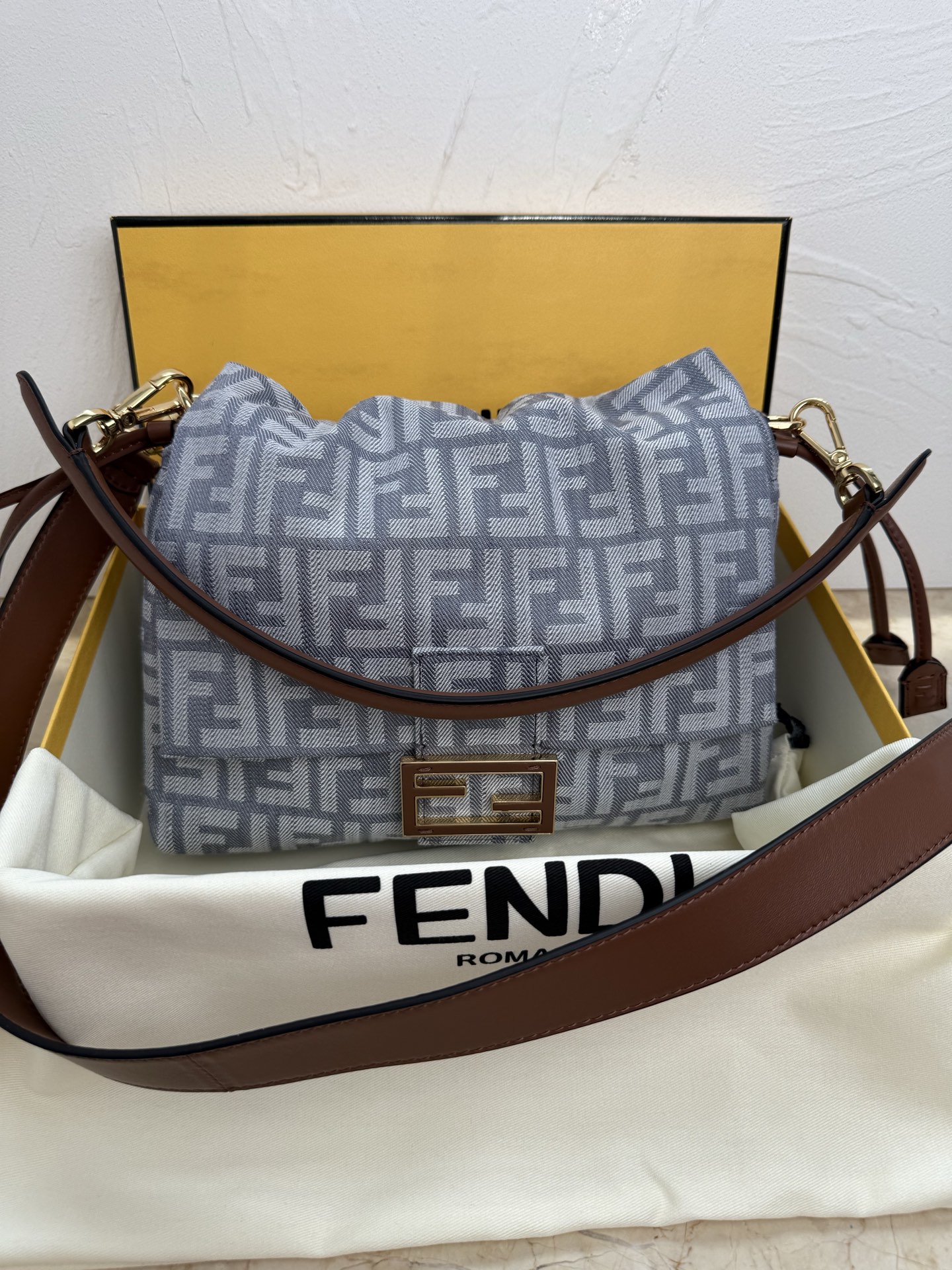 NO:389102,The iconic mid-sized Mamma Baguette handbag launched in the late 1990s is the large version of the iconic Baguette handbag, so it is called the Mamma Baguette. It was upgraded and improved during the 2025 Spring/Summer Fashion Show, with a deconstructed exterior design, retaining the classic elements of the handbag and the iconic underarm design. Jacquard fabric material is decorated with an iconic blue FF pattern, FF buckle and brown leather inlay. Large internal compartment, denim-effect jacquard fabric lining, drawstring closure with soft brown napa leather strap and custom detailing. Features a front flip and magnetic buckle. Gold-finished metal pieces. The handbag comes with removable brown napa leather handles and straps, which can be shoulder or crossbody. Made in Italy Model 8833 Material: fabric, sheepskin, inner lining: fabric Size:  ·Height: 18cm·Depth: 8.5cm·Length: 26.5cm·Length: 101cm·Length of shoulder strap: 45cm, sheepskin1986090920世纪90年代后期推出的标志性中号Mamma Baguette手袋是标志性 Baguette手袋的大号版本,因此被称为Mamma Baguette.在2025春夏时装秀中经过升级改良,采用解构外观设计,保留了手袋的经典元素和标志性的腋下设计. 提花布料材质,饰有标志性蓝色FF图案、FF搭扣和棕色皮革嵌饰.内部大隔层,牛仔面料效果提花布衬里,采用带柔软棕色纳帕皮革系带的拉绳开合和定制细节设计. 设有正面翻盖和磁扣.金色饰面金属件. 手袋配有可拆卸式棕色纳帕皮革提手和肩带,可肩背或斜挎.意大利制造 款号8833 材质:织物,羊皮革,内里:织物 尺寸: ·高度:18cm·深度:8.5cm·长度:26.5cm· 肩带长度101cm·肩带长度:45cm,,sheepskin,Bag