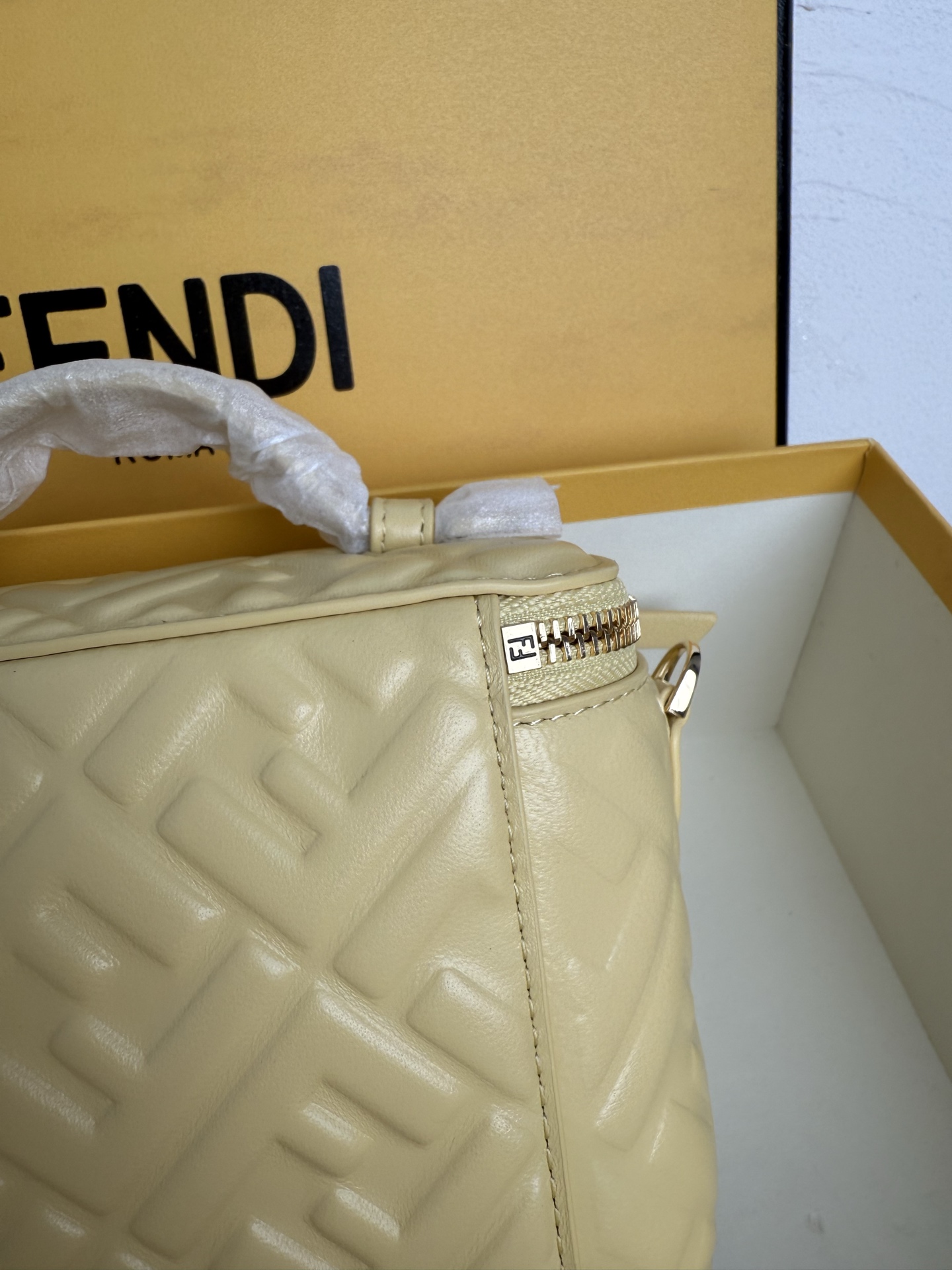 Fendi 廓形挺立的小巧型Vanity手袋采用双滑动拉链开合设计，饰有FF细节和皮革拉链头。烟草棕FF提花布料材质
