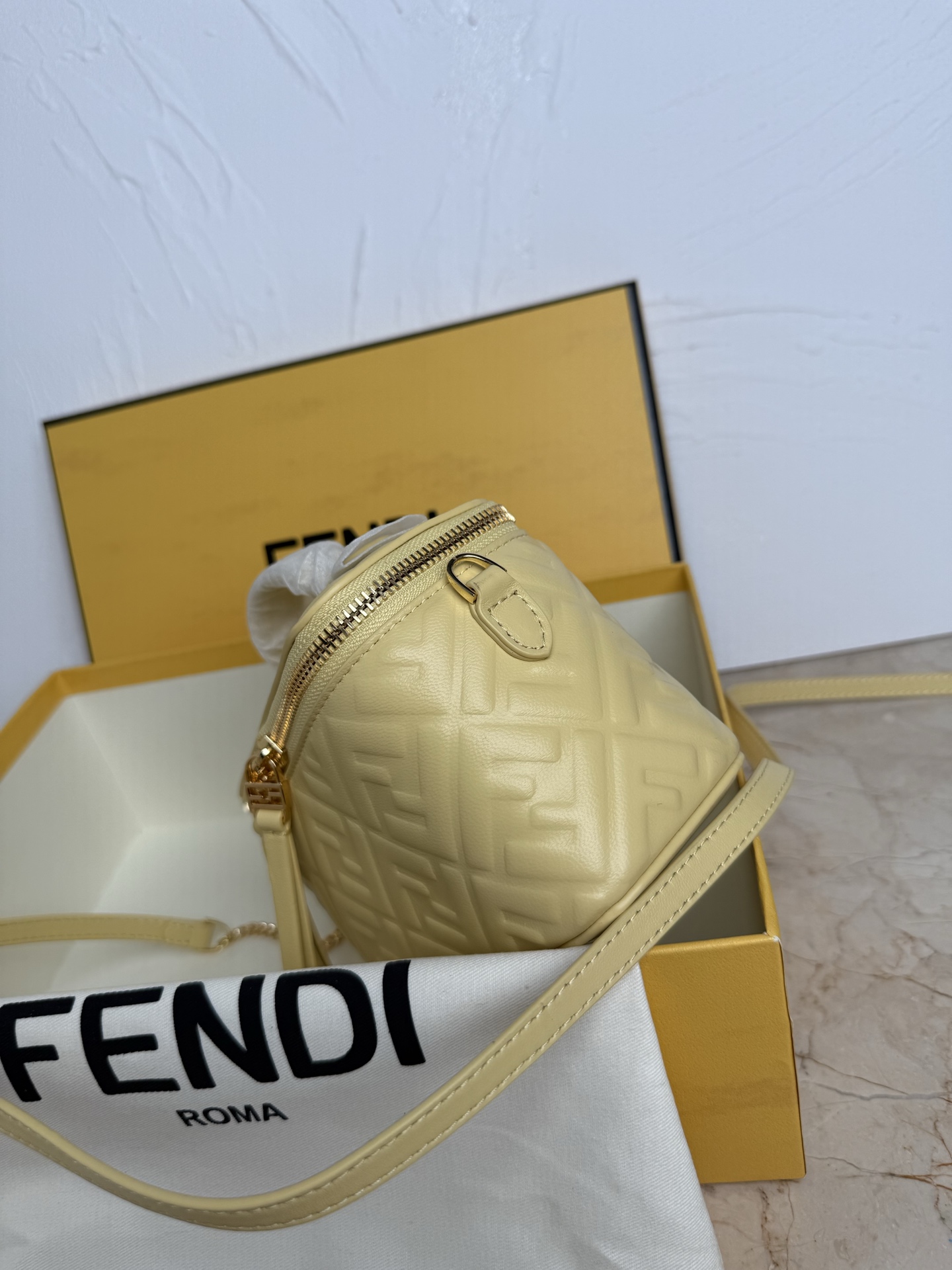 Fendi 廓形挺立的小巧型Vanity手袋采用双滑动拉链开合设计，饰有FF细节和皮革拉链头。烟草棕FF提花布料材质