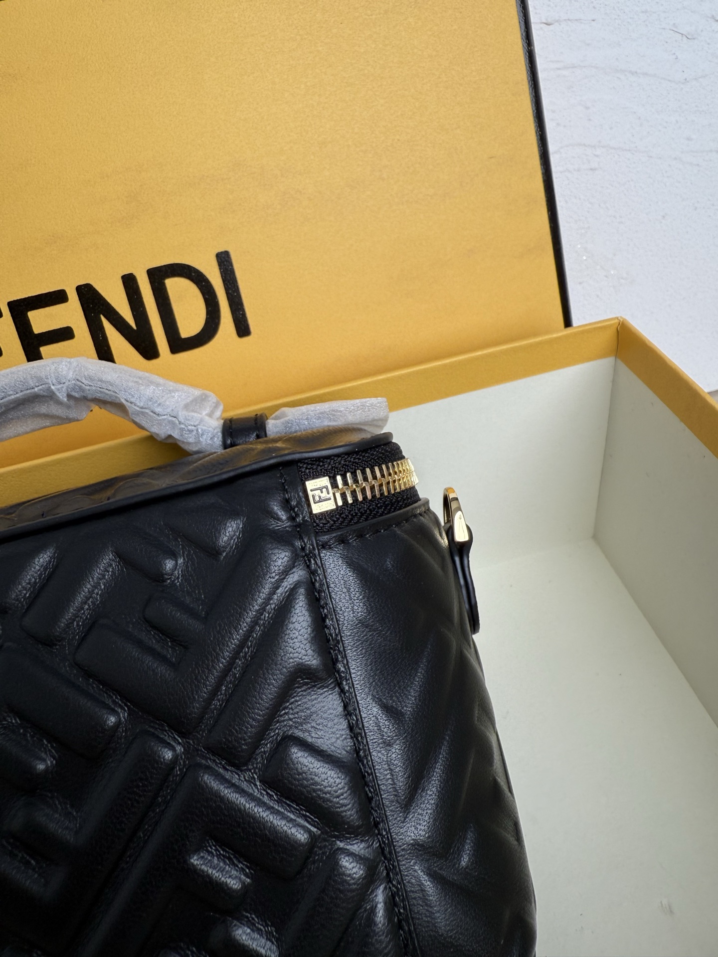 Fendi 廓形挺立的小巧型Vanity手袋采用双滑动拉链开合设计，饰有FF细节和皮革拉链头。烟草棕FF提花布料材质
