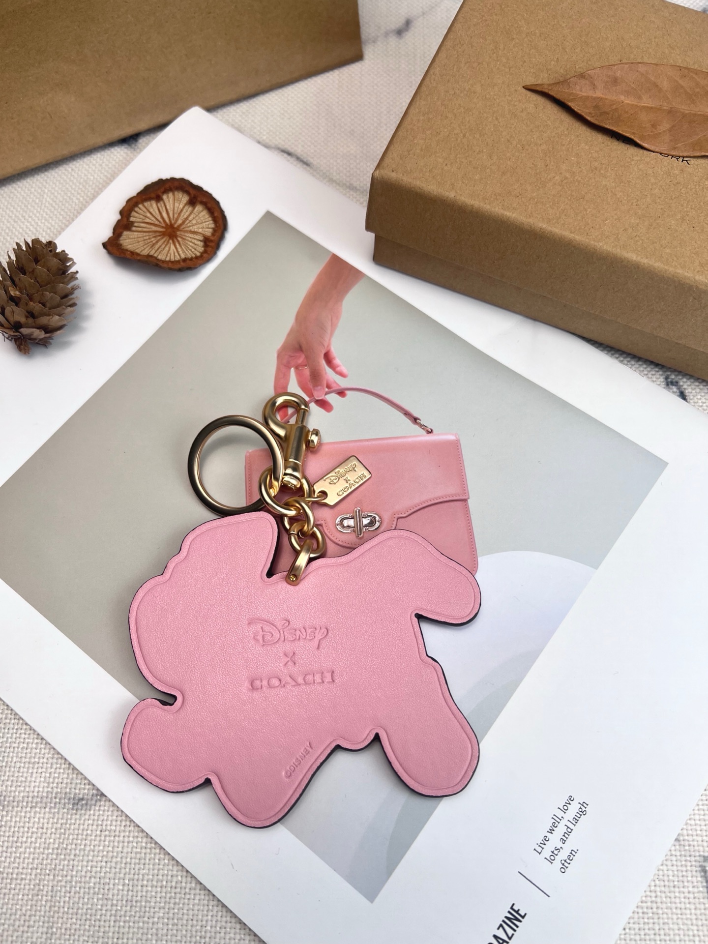 Coach x Disney联名斑点狗挂件，灵感来自《101忠狗》，皮革材质+粉色边框，少女感满满。金属五金连接，适合包包或钥匙扣，小巧可爱，收藏价值高，迪士尼粉丝必入!日常搭配或送礼都超合适门，组细节精致，兼具实用与趣味，出门也能萌趣加分~
尺寸11*9*1cm