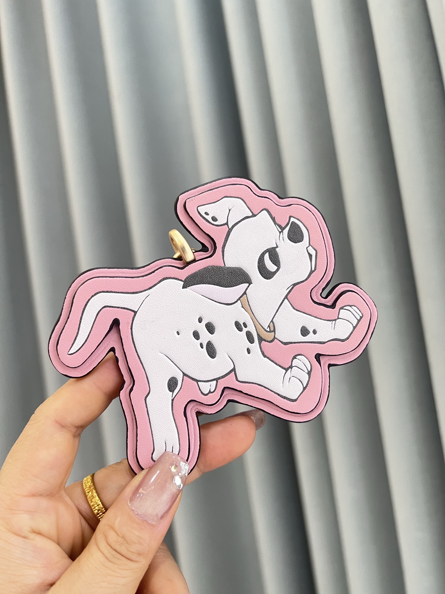 Coach x Disney联名斑点狗挂件，灵感来自《101忠狗》，皮革材质+粉色边框，少女感满满。金属五金连接，适合包包或钥匙扣，小巧可爱，收藏价值高，迪士尼粉丝必入!日常搭配或送礼都超合适门，组细节精致，兼具实用与趣味，出门也能萌趣加分~
尺寸11*9*1cm