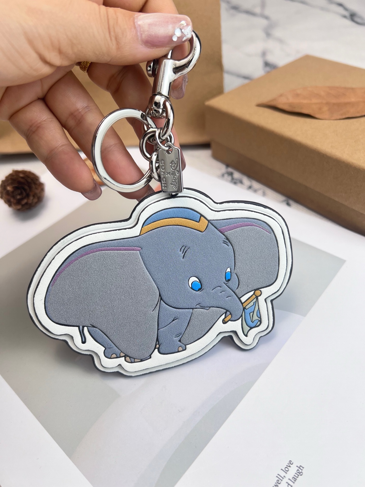 Coach x Disney联名的小飞象挂件，皮革材质+经典卡通造型，细节超还原!金属钥匙扣，包
包、钥匙都能挂，实用又可爱计。尺寸刚好，日常搭配无压力，迪士尼粉丝必收，送礼or自留都超合适，童心满满，收藏价值也很高哦!
尺寸8*12cm