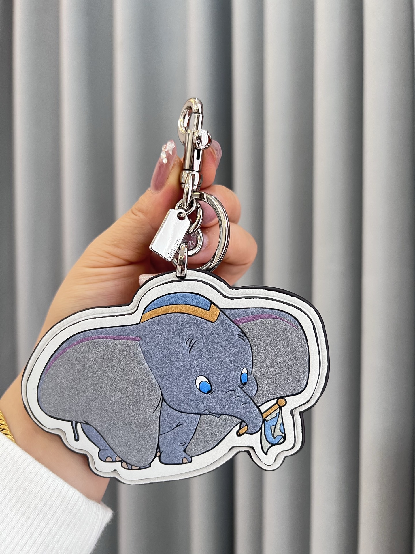 Coach x Disney联名的小飞象挂件，皮革材质+经典卡通造型，细节超还原!金属钥匙扣，包
包、钥匙都能挂，实用又可爱计。尺寸刚好，日常搭配无压力，迪士尼粉丝必收，送礼or自留都超合适，童心满满，收藏价值也很高哦!
尺寸8*12cm