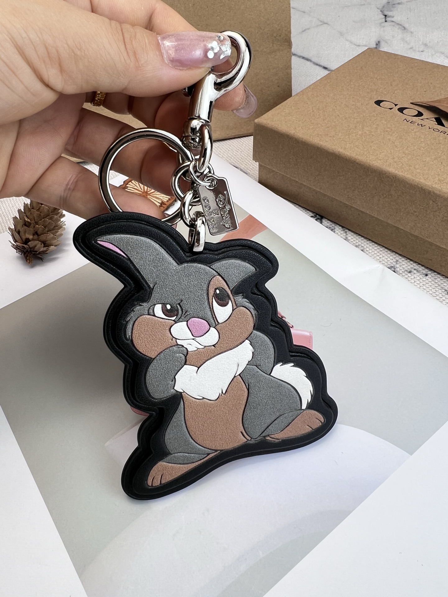🐰Coach和Disney联名推出的Thumper挂件，灵感来自《小鹿斑比》，皮革材质+经典轮廓，细节超还原!金属钥匙扣+Coach标志吊牌，实用又有辨识度计。尺寸适中，包包、钥匙都能挂，装饰感满分，收藏价值也很高~迪士尼粉丝和Coach控必入，送礼自留都超合适
尺寸：8.25*10.16