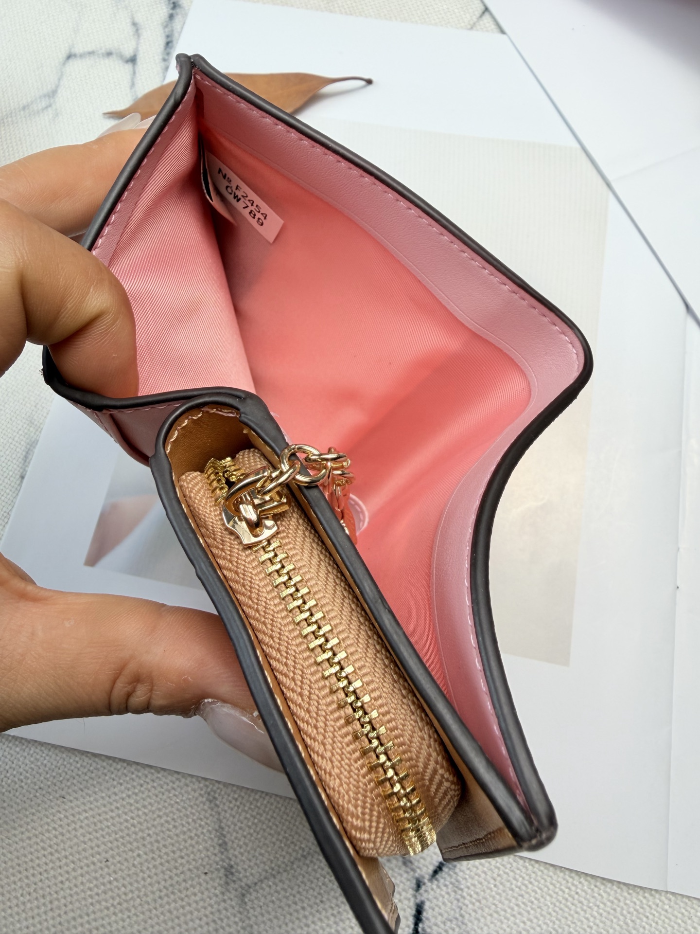 Coach COACH樱花粉 采用优质牛皮 表面细腻纹理 触感柔软又耐用 链条 挂着山茶花花瓣