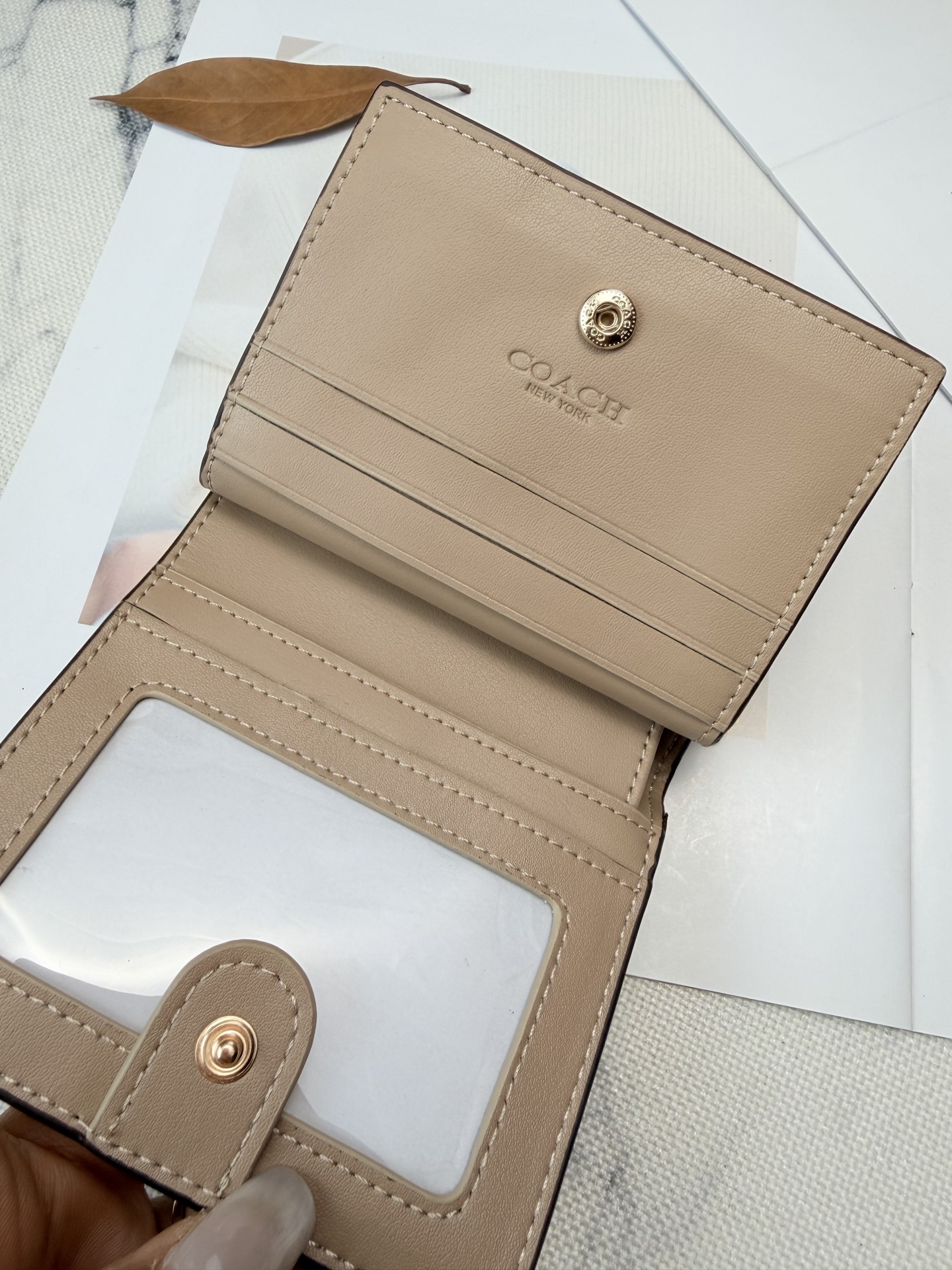 Coach COACH这款女士短款CCL79零钱卡包 采用优质白色漆皮配奶茶色平纹真皮设计 手感细腻耐用